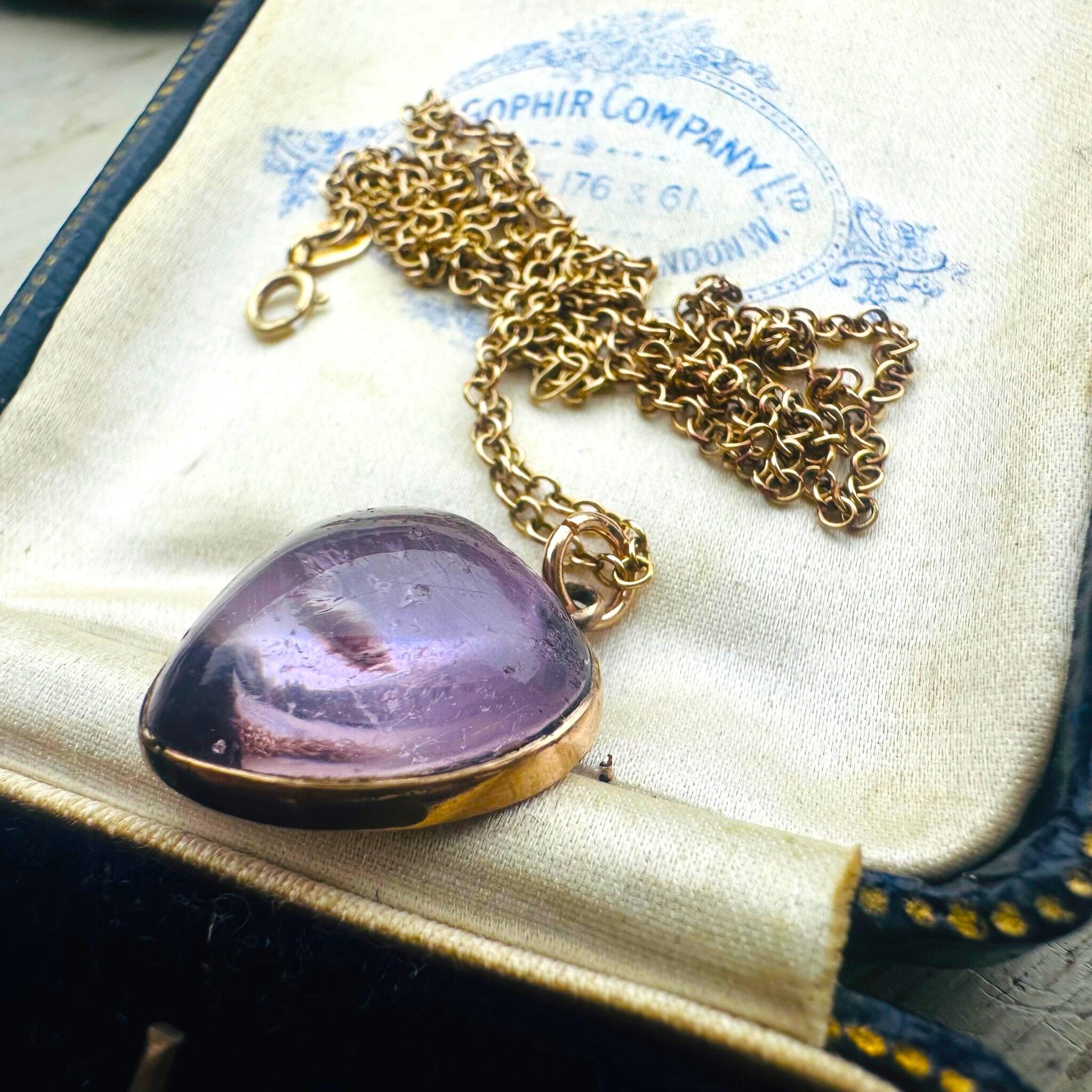 flat profile of Rose de France Amethyst Heart Pendant & Gold rolo link chain displayed on antique box