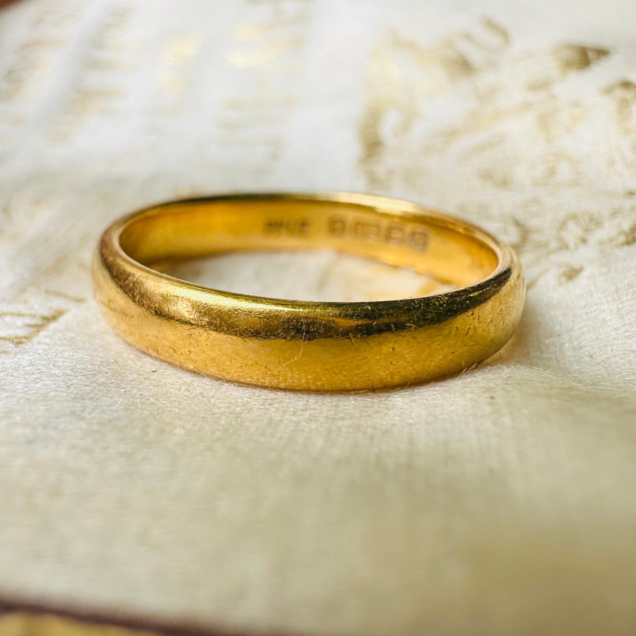 close up of Vintage 22k Gold Wedding Band Ring displayed on antique box