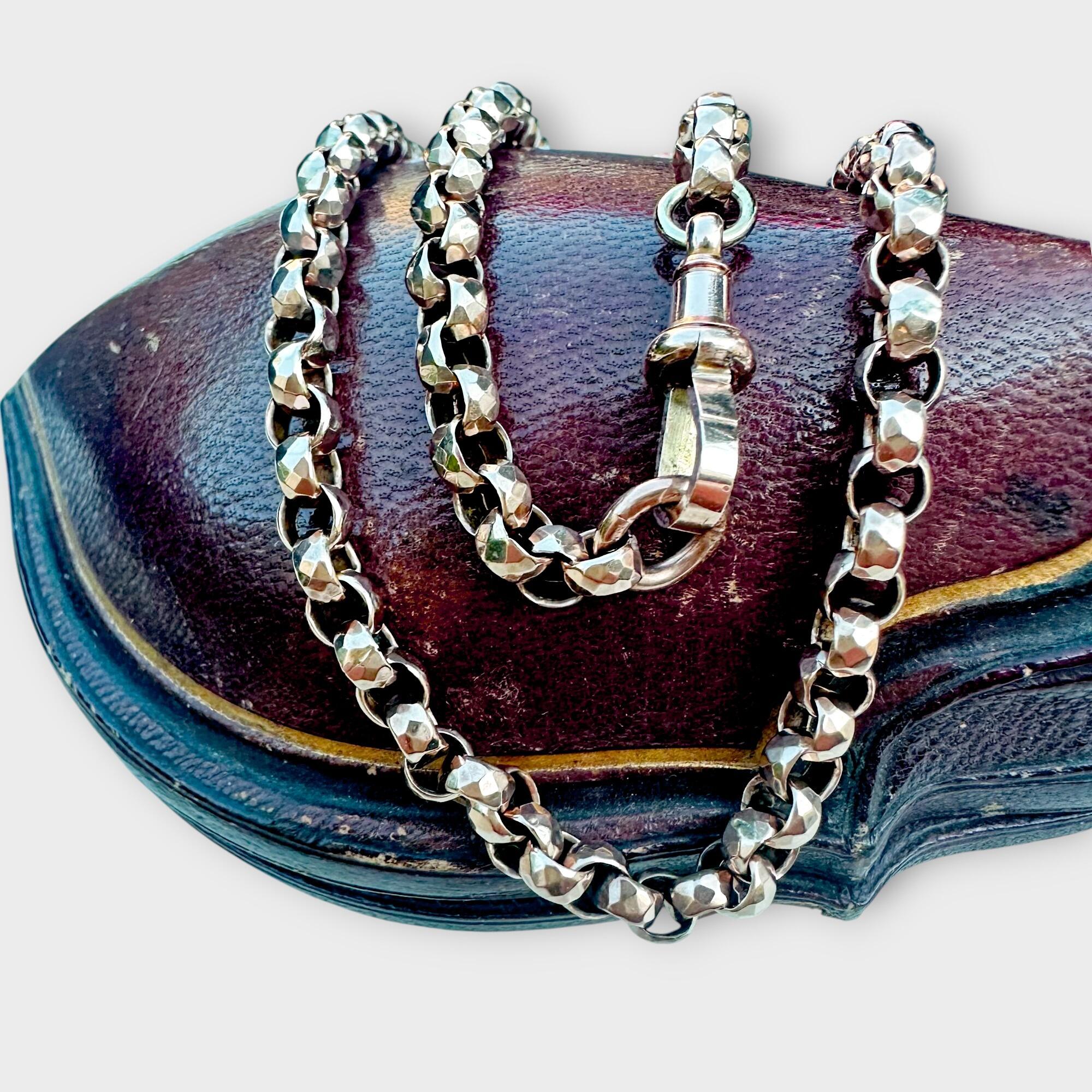 Close-up of faceted belcher links in 9ct rose gold, showing intricate Victorian hand craftsmanship and warm rose gold hue on leather antique box.