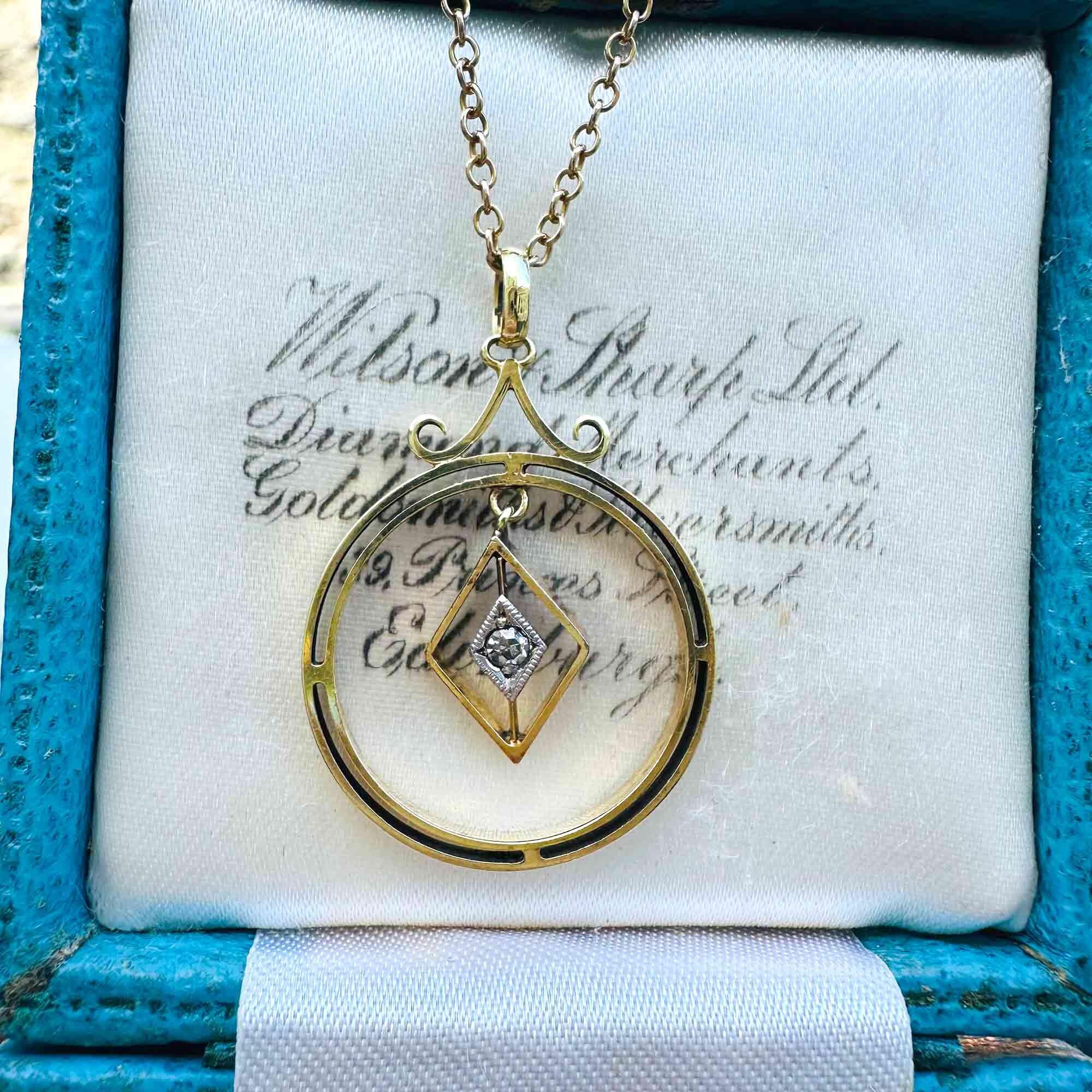 Front view of Art Deco 15k gold pendant with central diamond and geometric design.