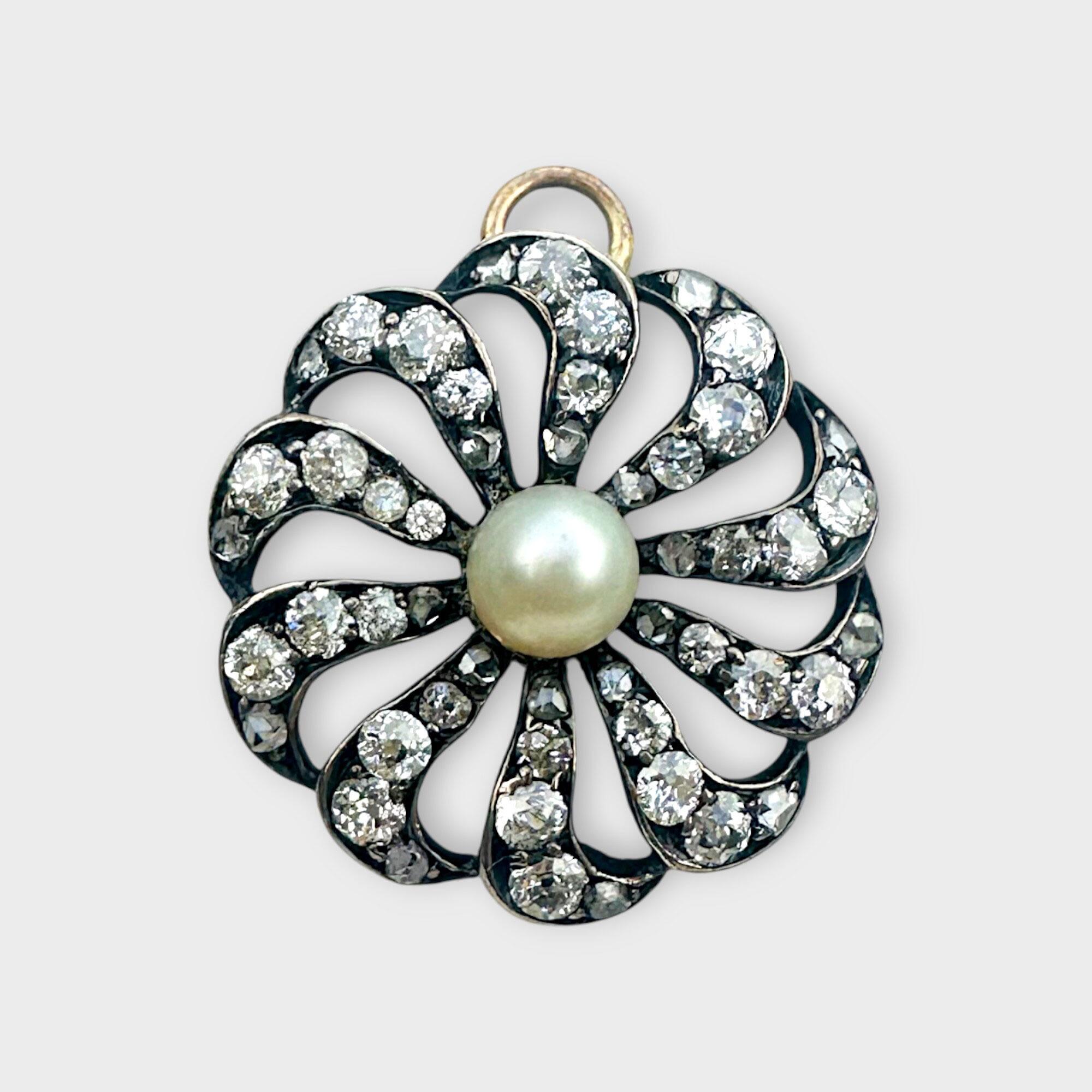 antique diamond and pearl celestial sunburst pendant with a grey background.