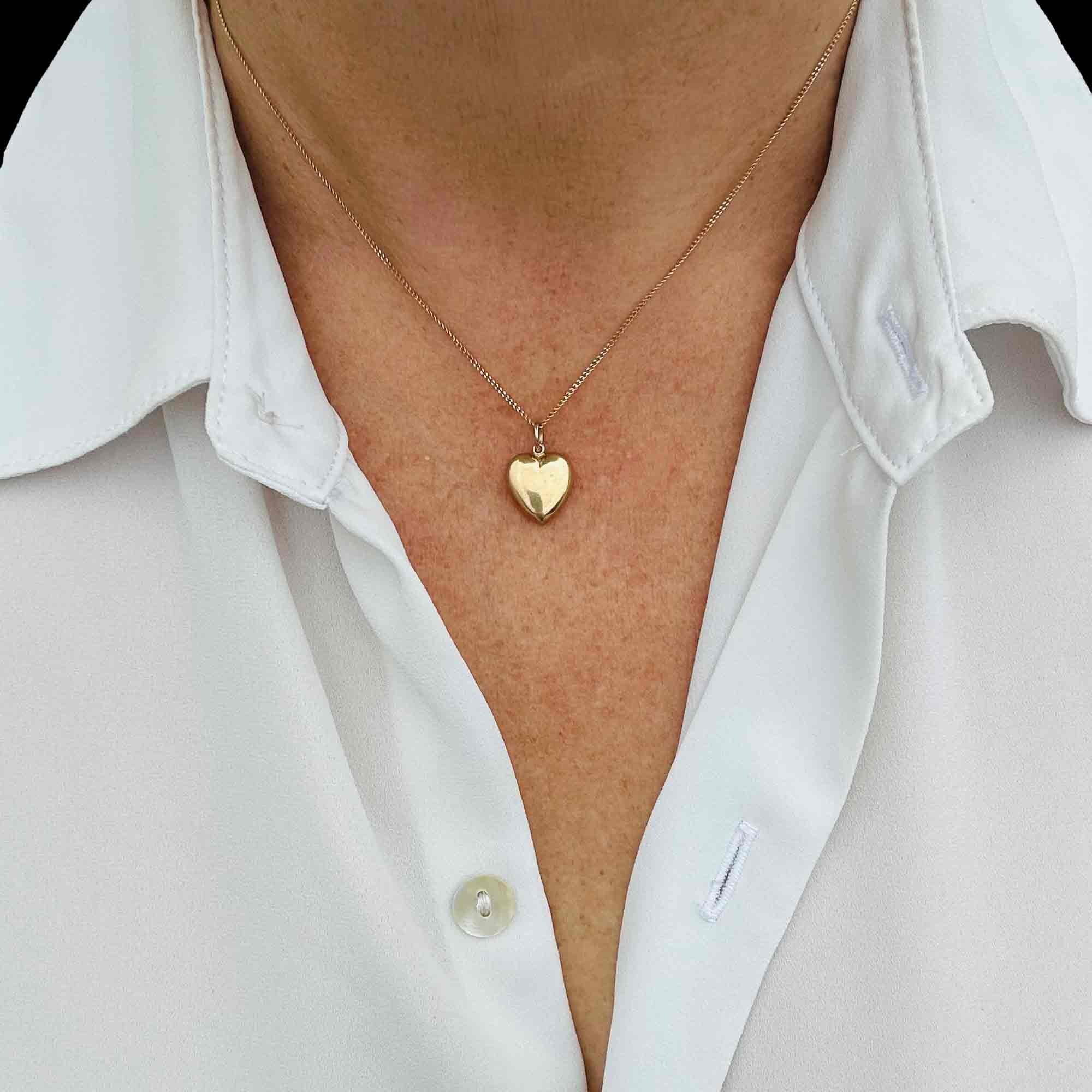Gold Puffy Heart Necklace with Chain Dating 1942, worn around models neck.