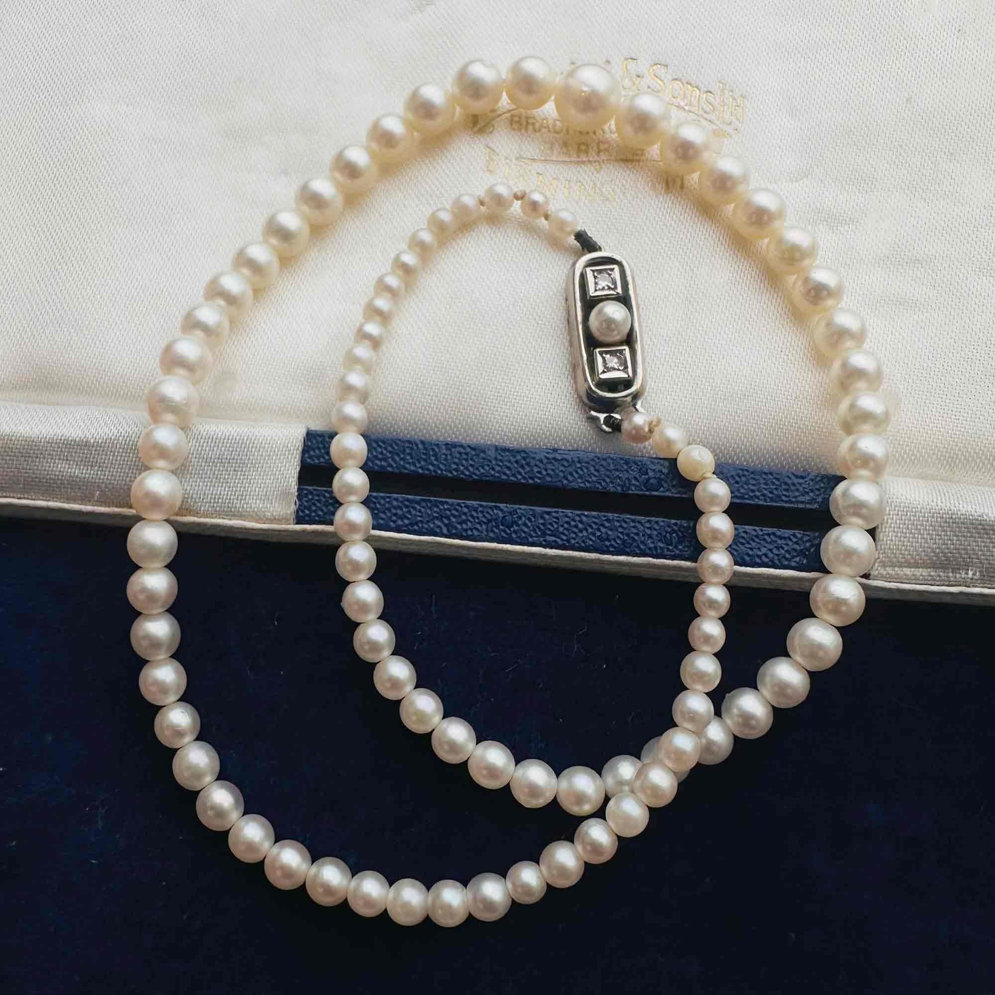Saltwater Cultured Pearl & 14ct White Gold Diamond Clasp Necklace, displayed on antique box.