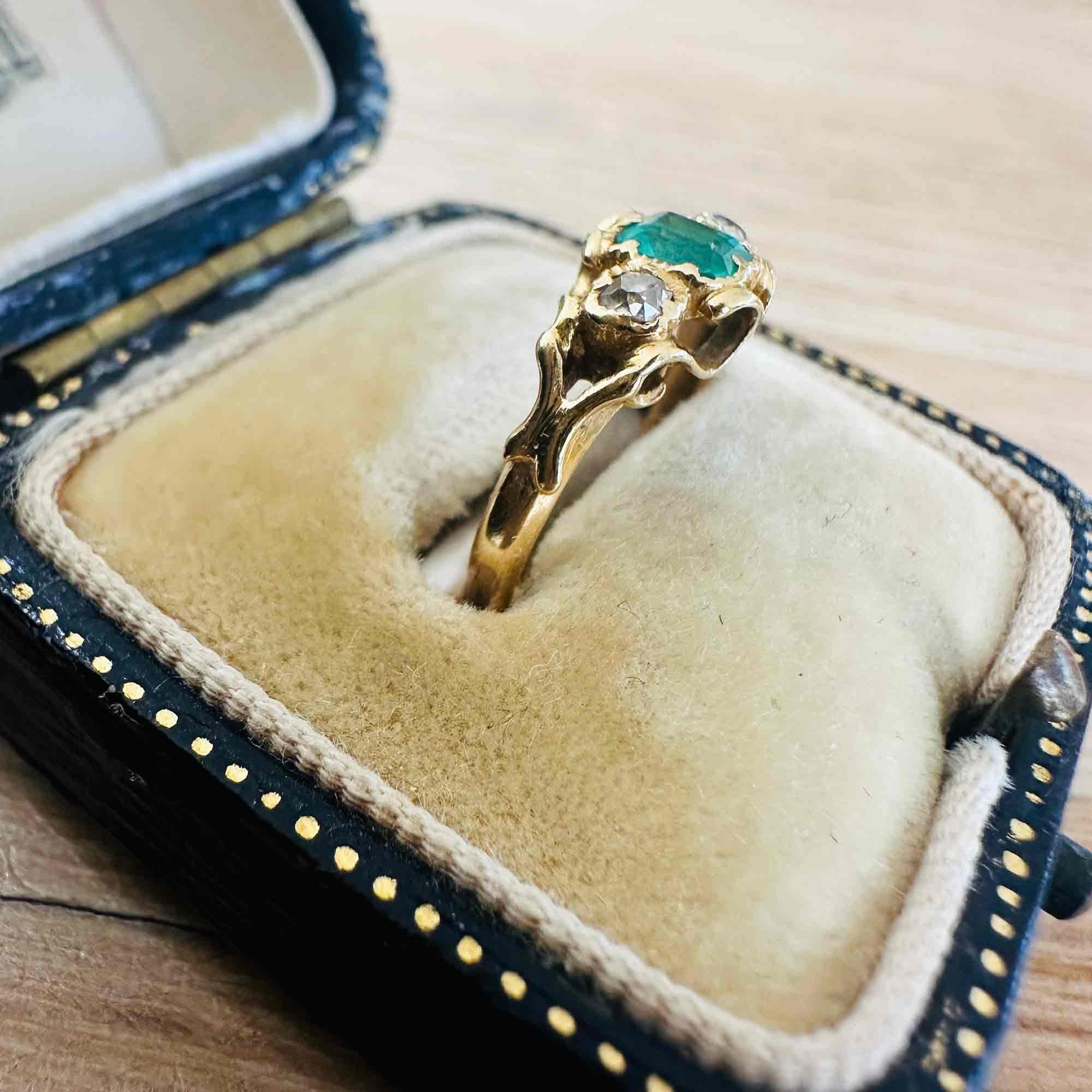 side view of Emerald & Diamond Three Stone Victorian Ring displayed on antique box