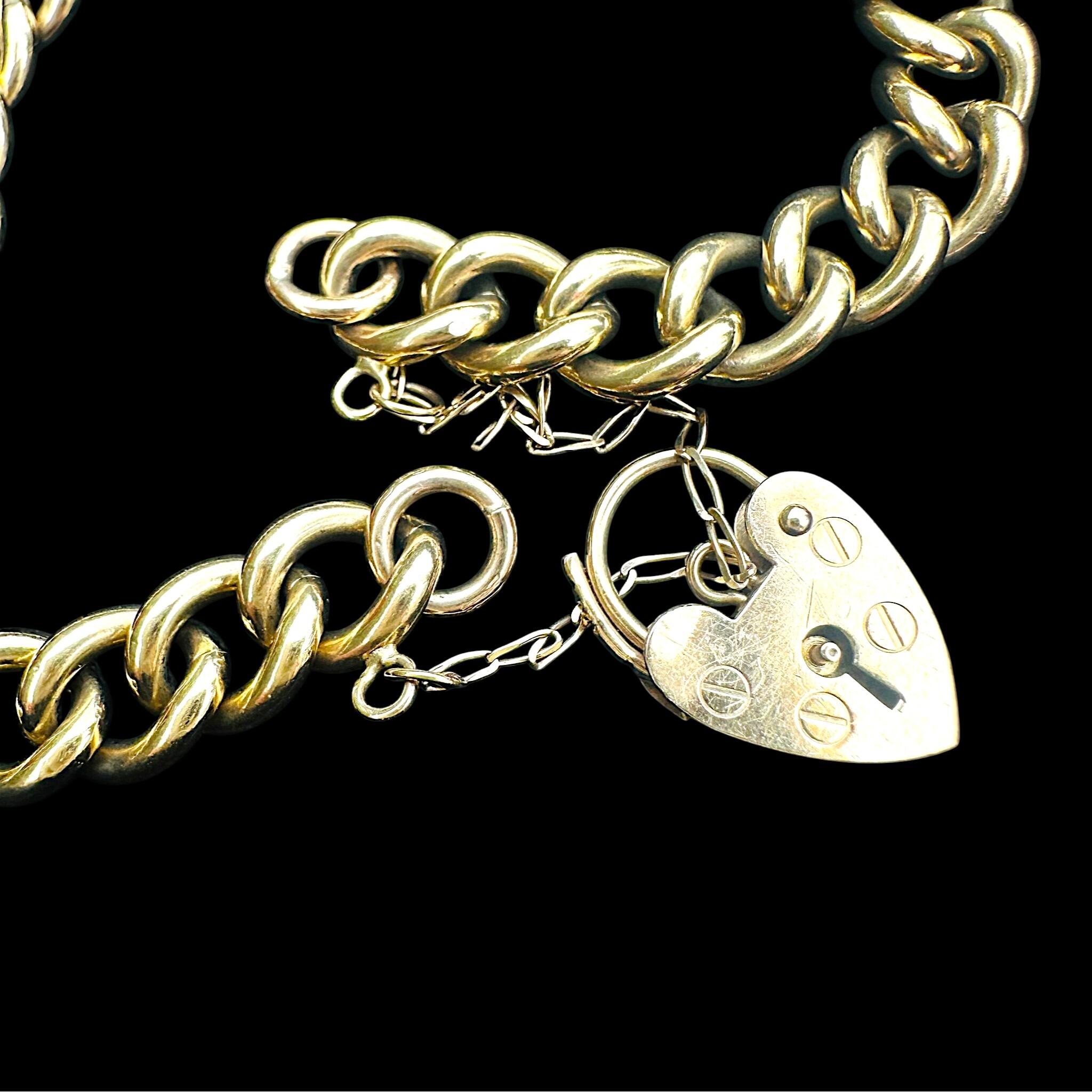 close up of Heavy, Chunky Gold Curb Bracelet & Heart Padlock displayed on antique box