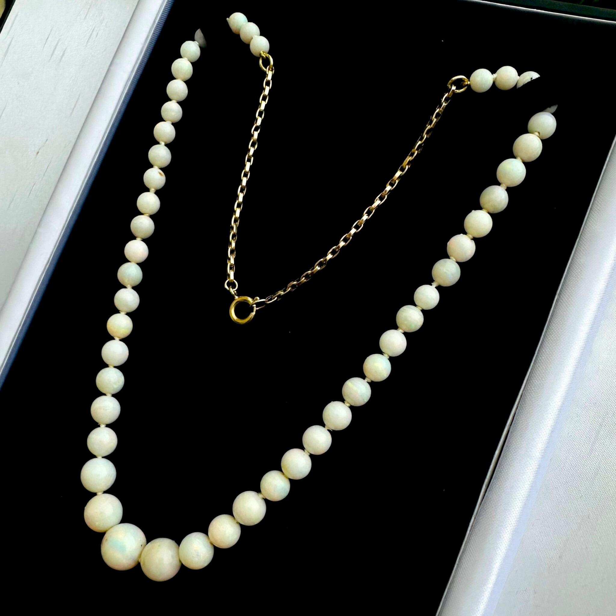 side view of Art Deco Graduated Opal Bead & Gold Bike Chain Necklace displayed on black velvet