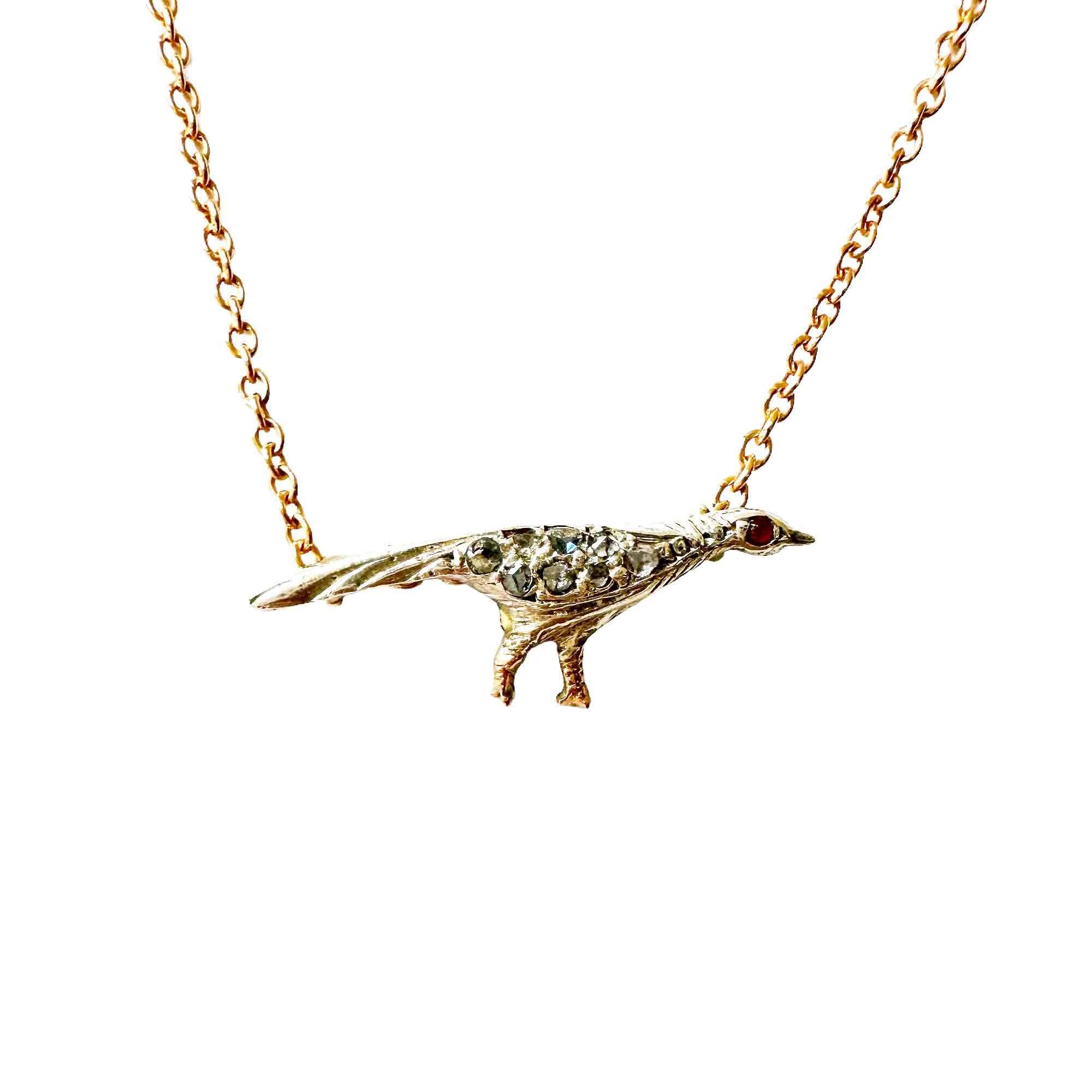 diamond and ruby pheasant pendant attached to a gold chain, with white background