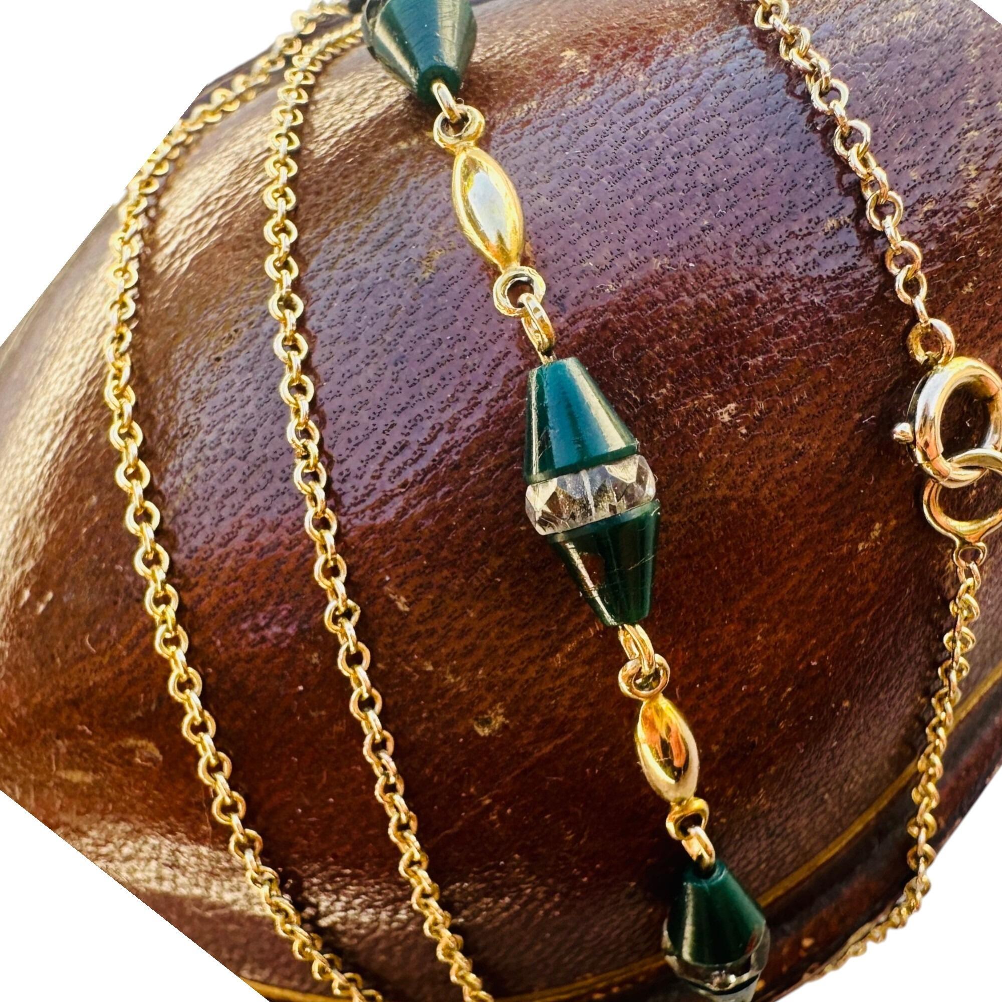 close up of Antique Art Deco 9k Gold Bloodstone & Rock Crystal Bead Chain displayed on red leather box with white background