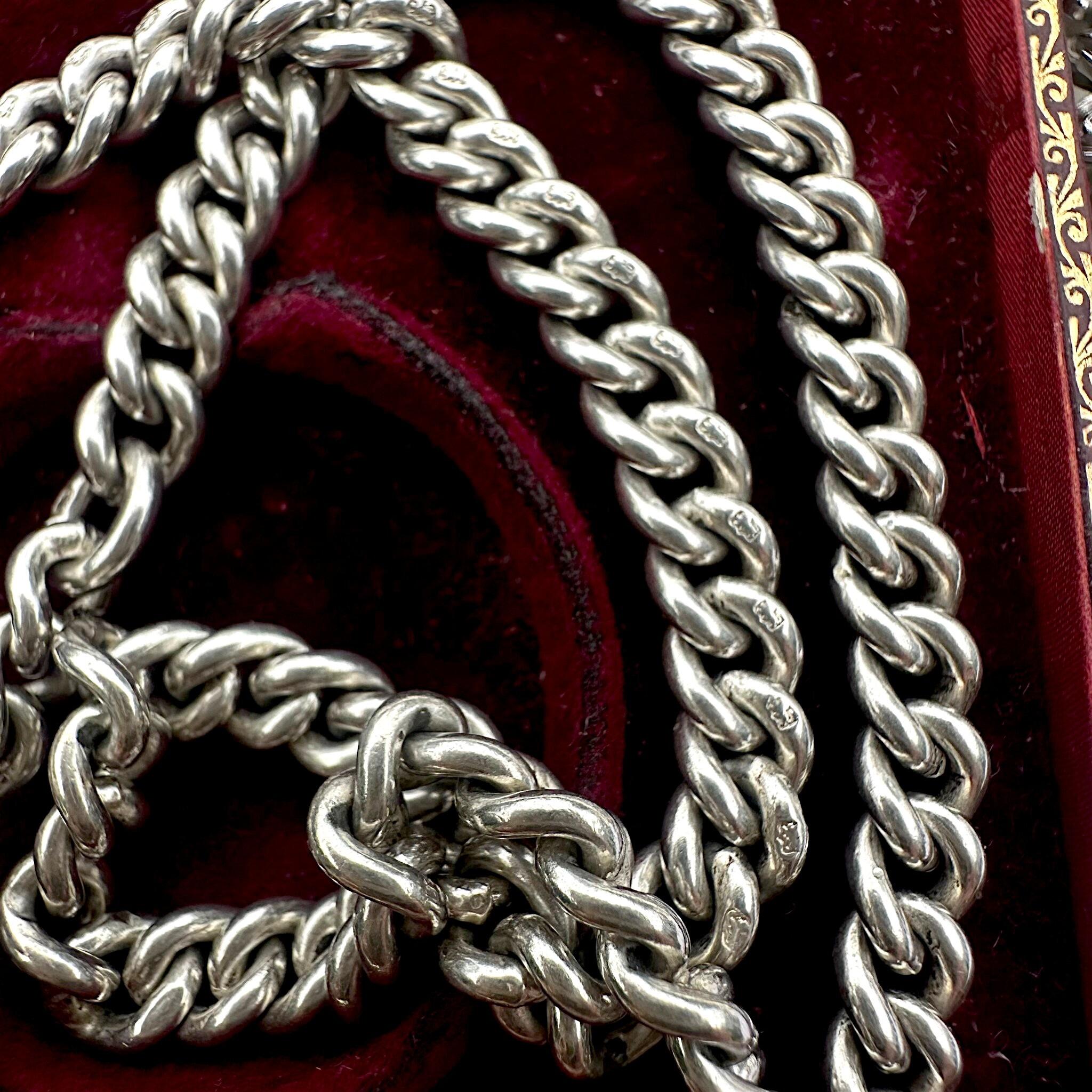 close up of Antique Edwardian Sterling Silver Albert Chain, T Bar & Dog Clip displayed on red velvet
