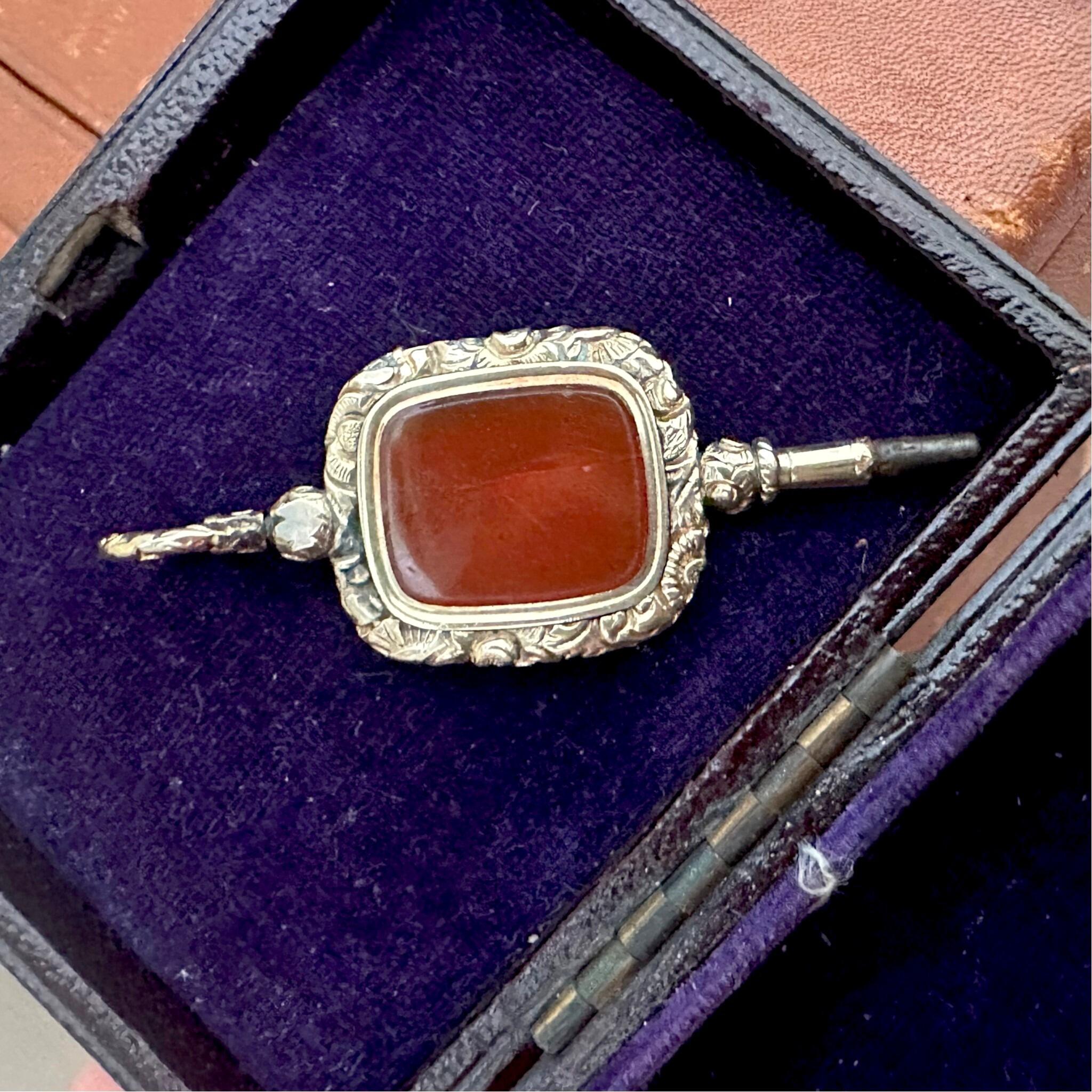 Antique Georgian Carnelian Watch Key Pendant displayed on purple velvet box