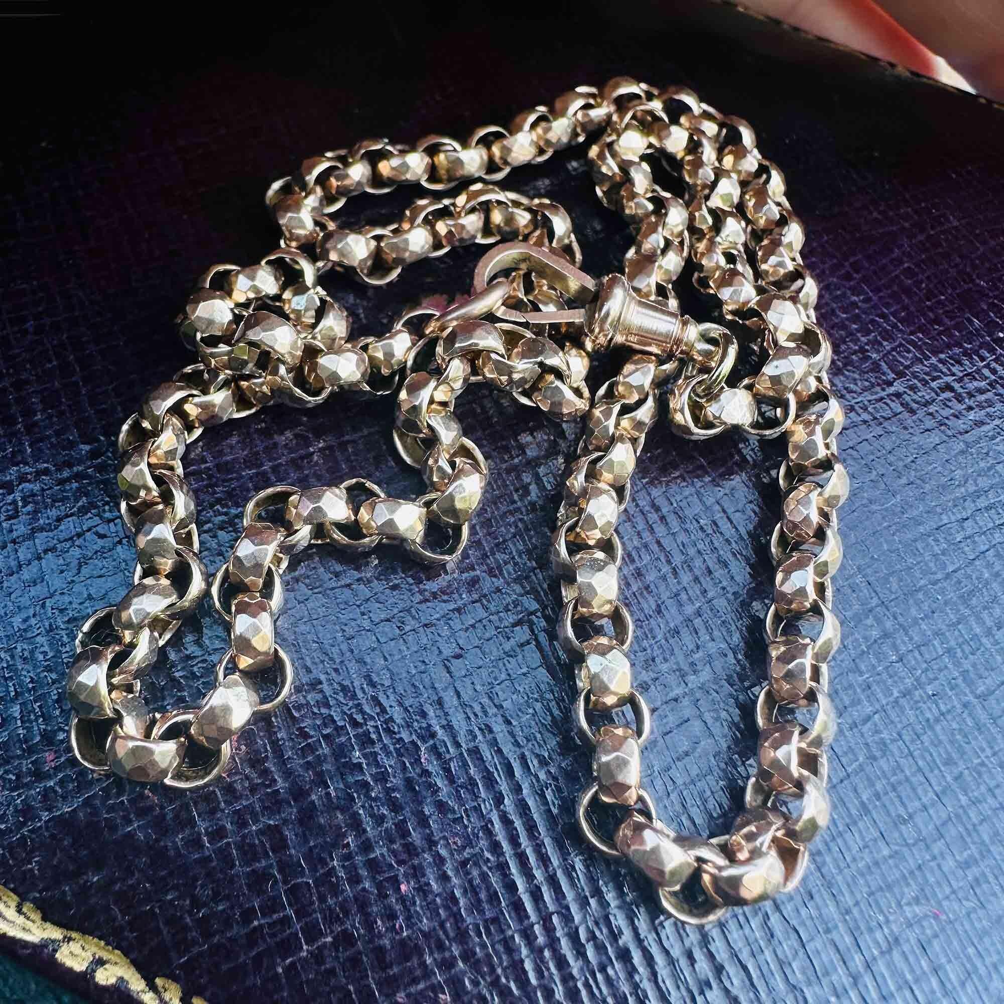 Close-up of faceted belcher links in 9ct rose gold, showing intricate Victorian hand craftsmanship and warm rose gold hue on leather antique box.