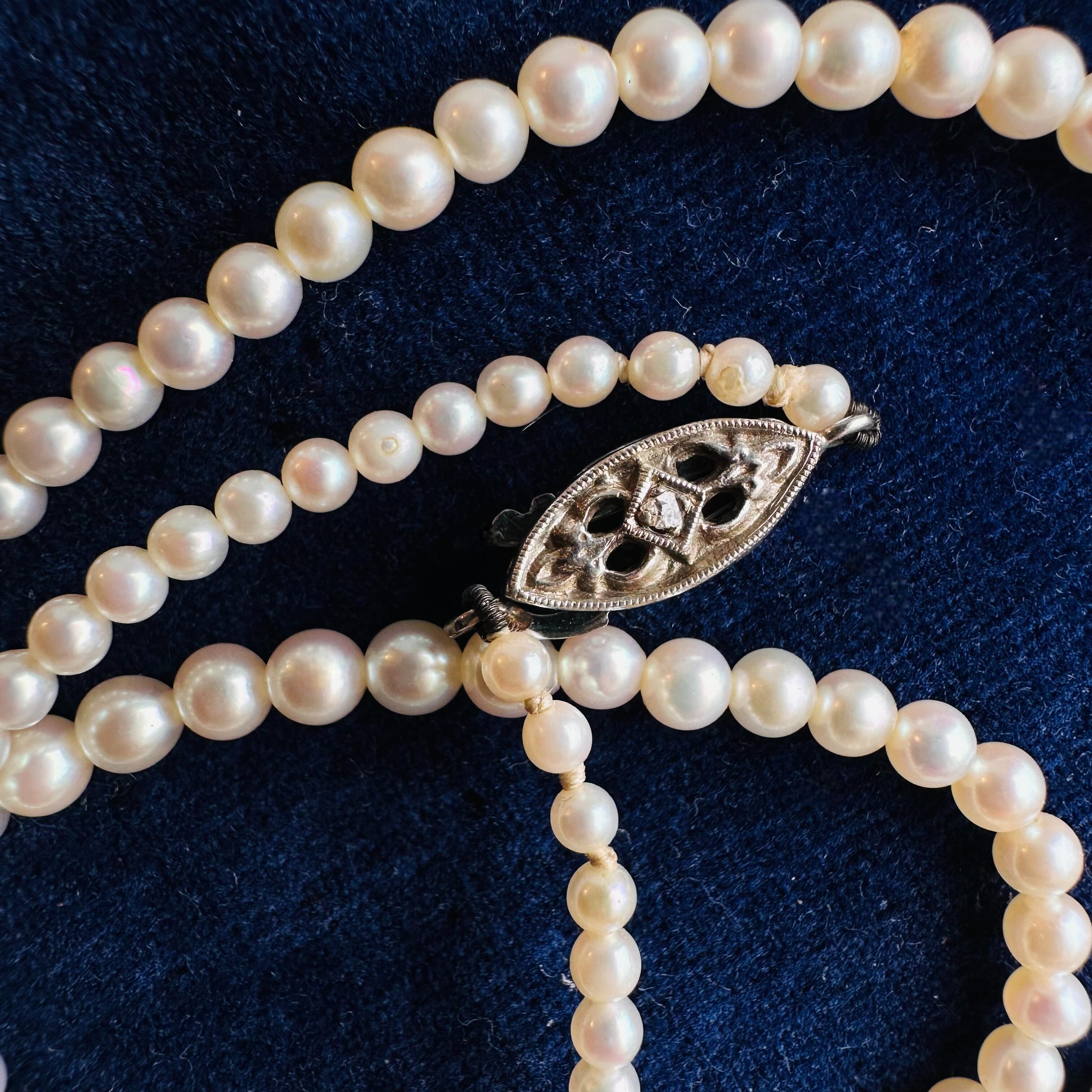 White Gold & Diamond, Saltwater Cultured Pearl Necklace displayed on antique box