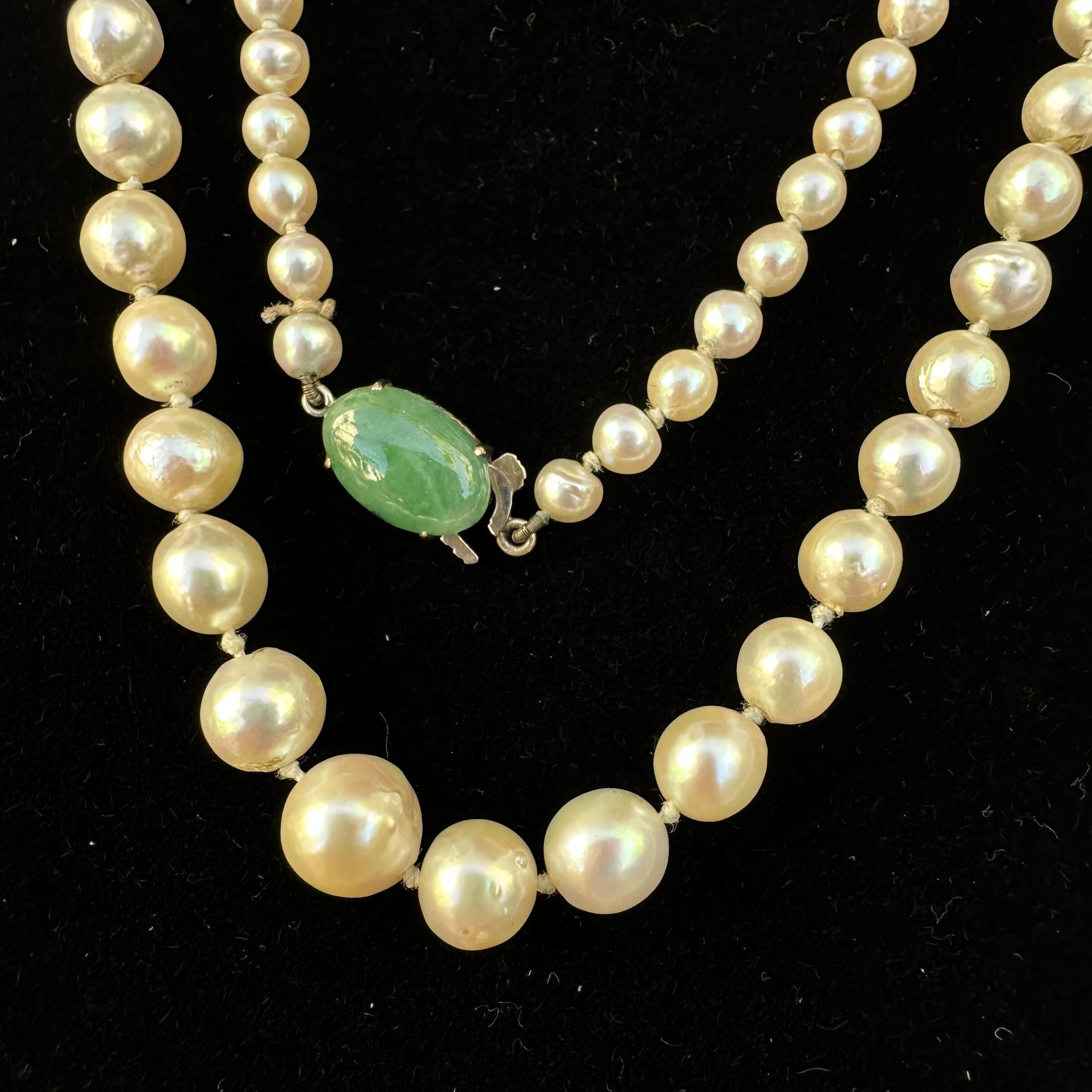 close up of Antique Cultured Saltwater Baroque Pearl & 14k Gold Jadeite Clasp Necklace displayed on black velvet