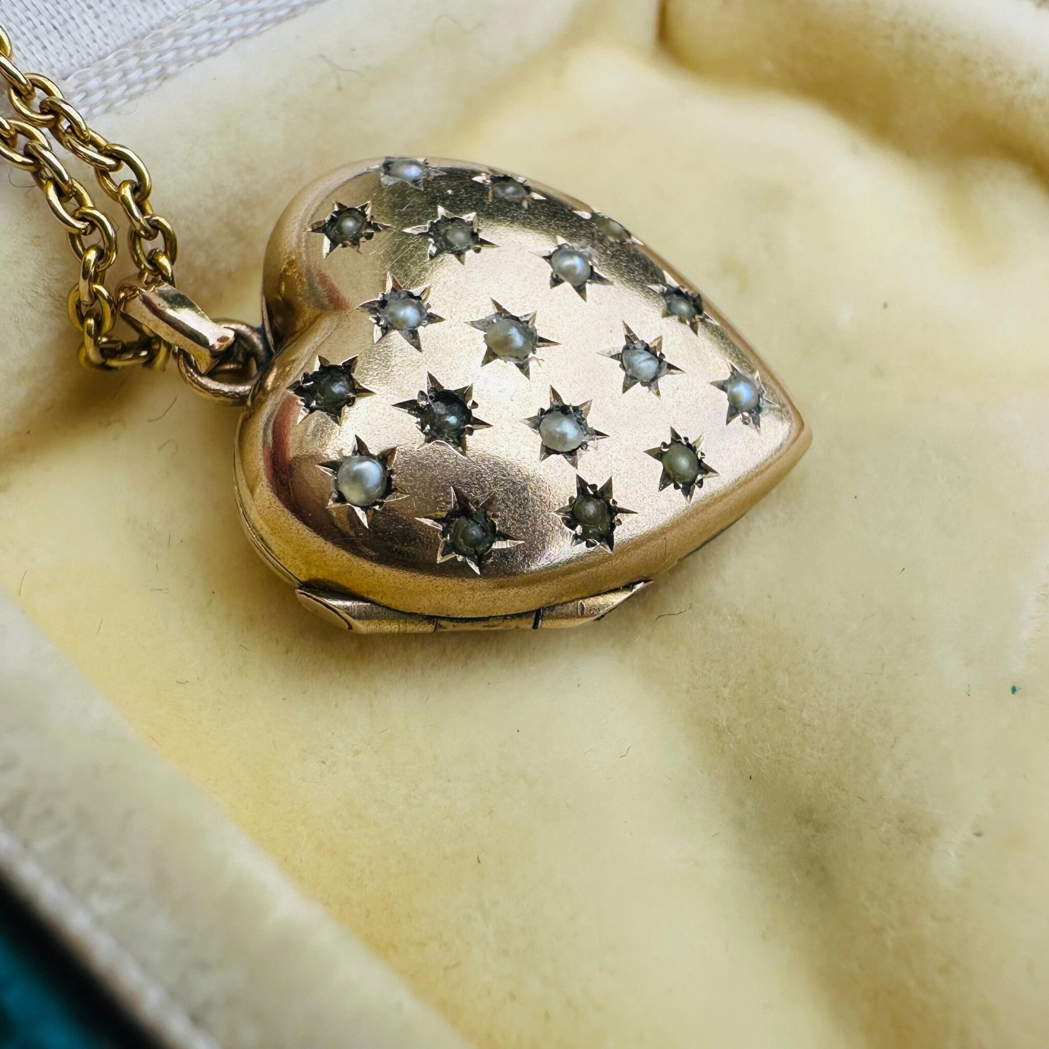 side profile of Vintage Gold Pearl Star Set Puffy Heart Locket displayed on antique box