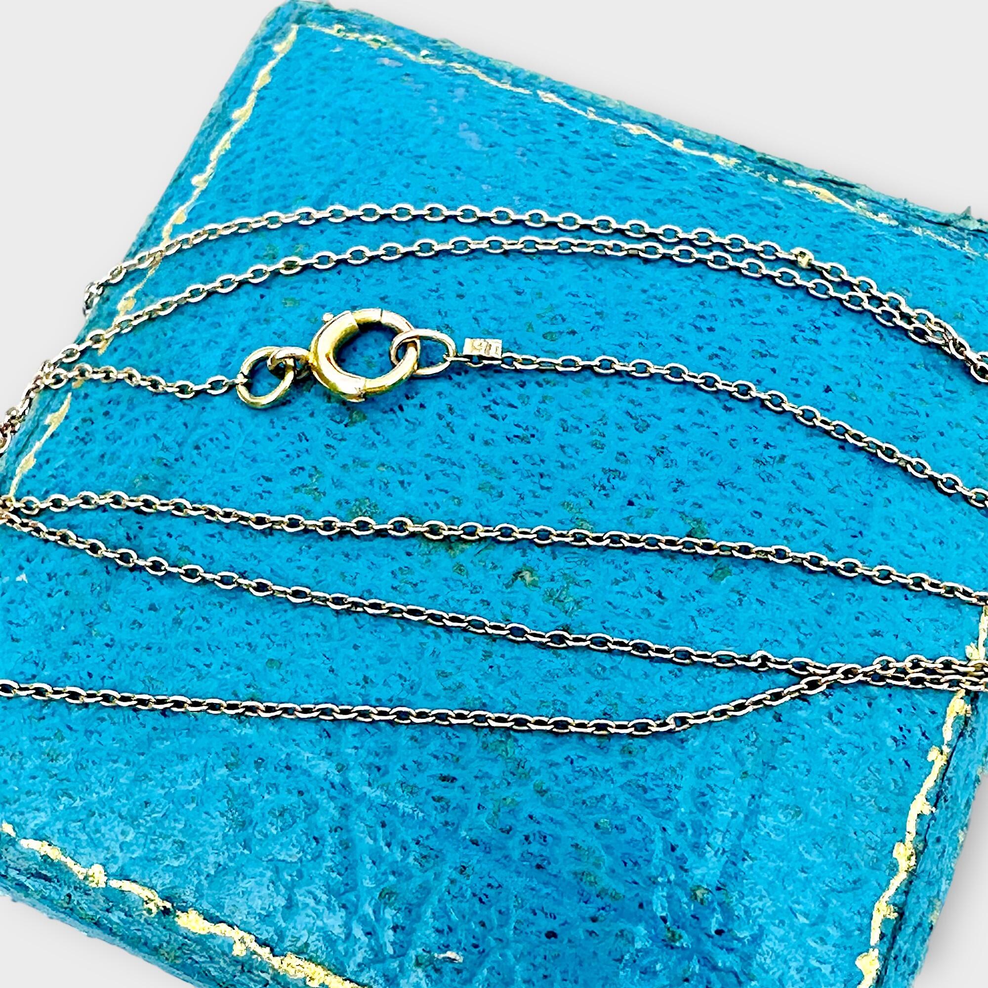 Close-up of rare antique Edwardian 15k gold rolo link chain, displayed on a blue antique box.