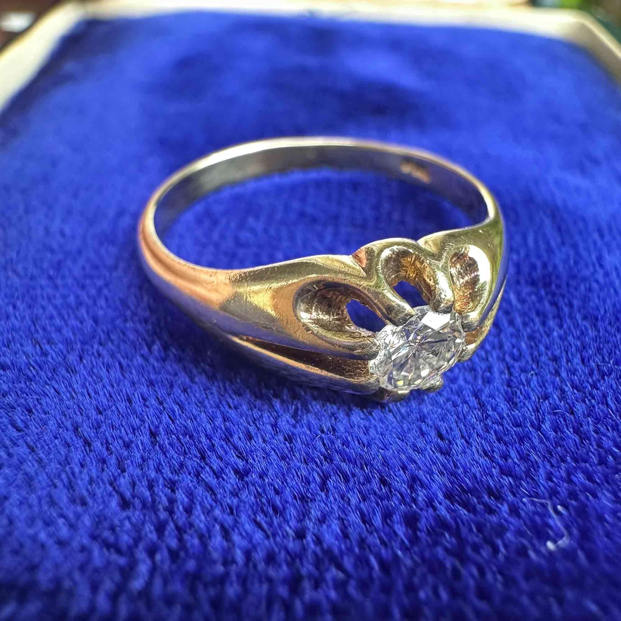 side view of gents gold diamond solitaire gypsy ring on blue velvet pad