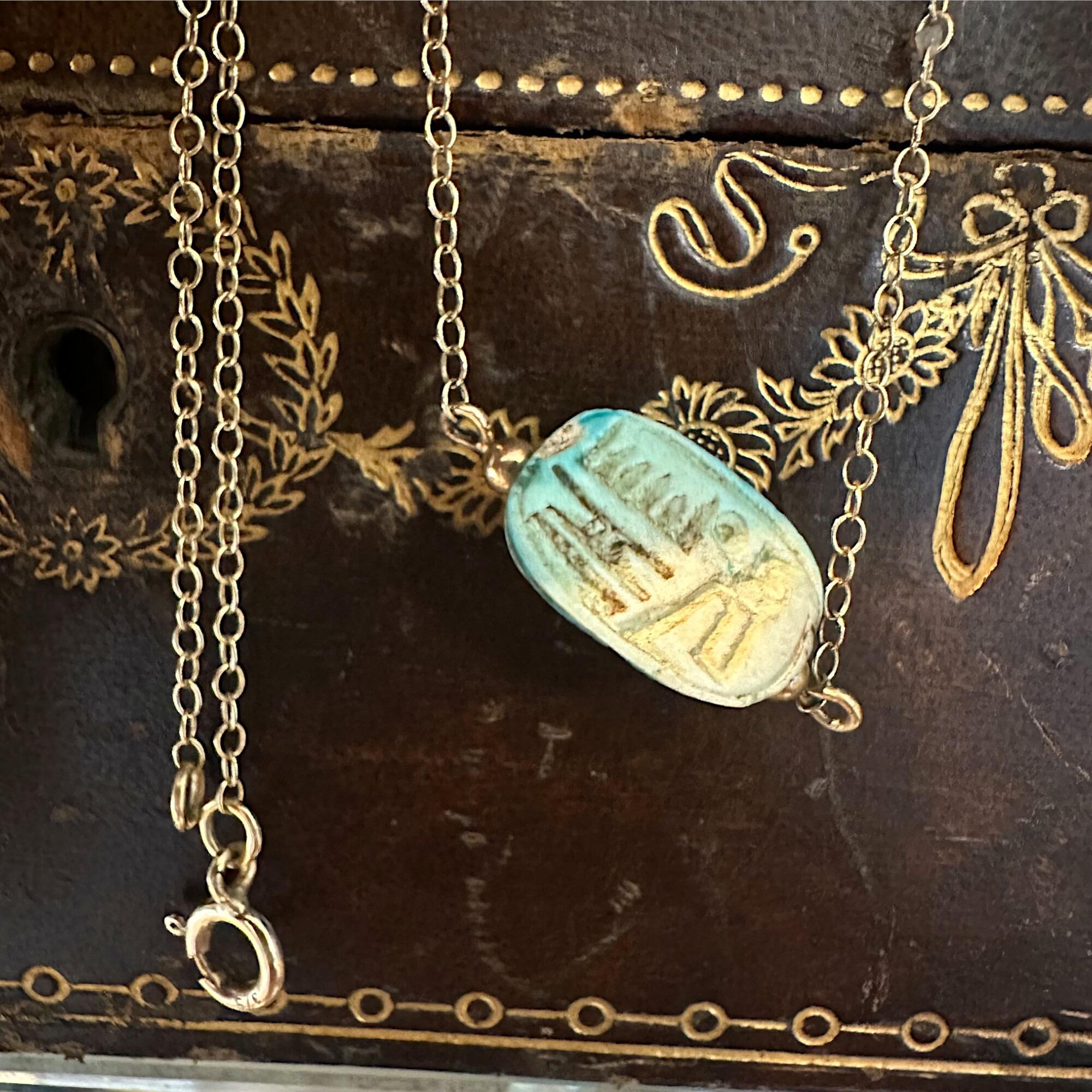 rear view,9k Gold Blue Faience Scarab Necklace – Egyptian Revival Pendant displayed on antique box
