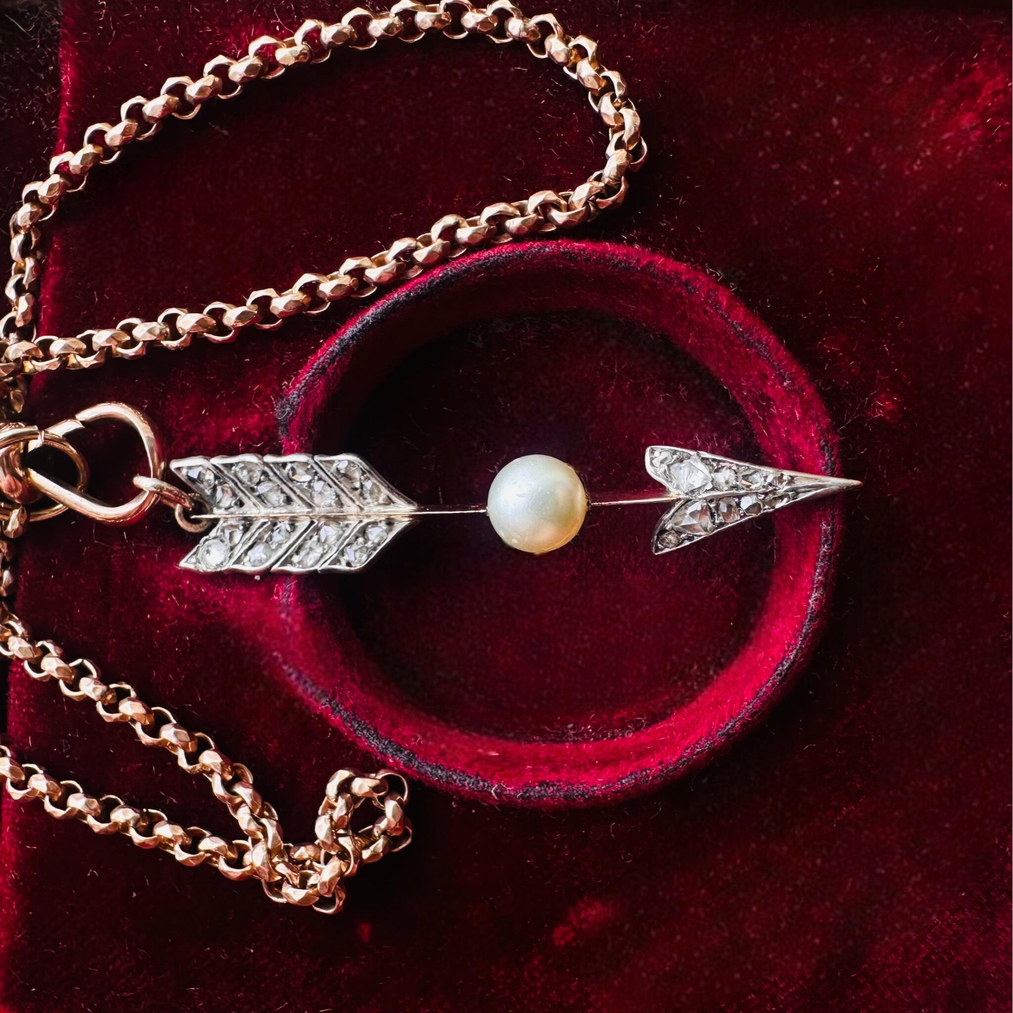 Victorian Rose Cut Diamond & Pearl Cupid’s Arrow Pendant displayed on red velvet