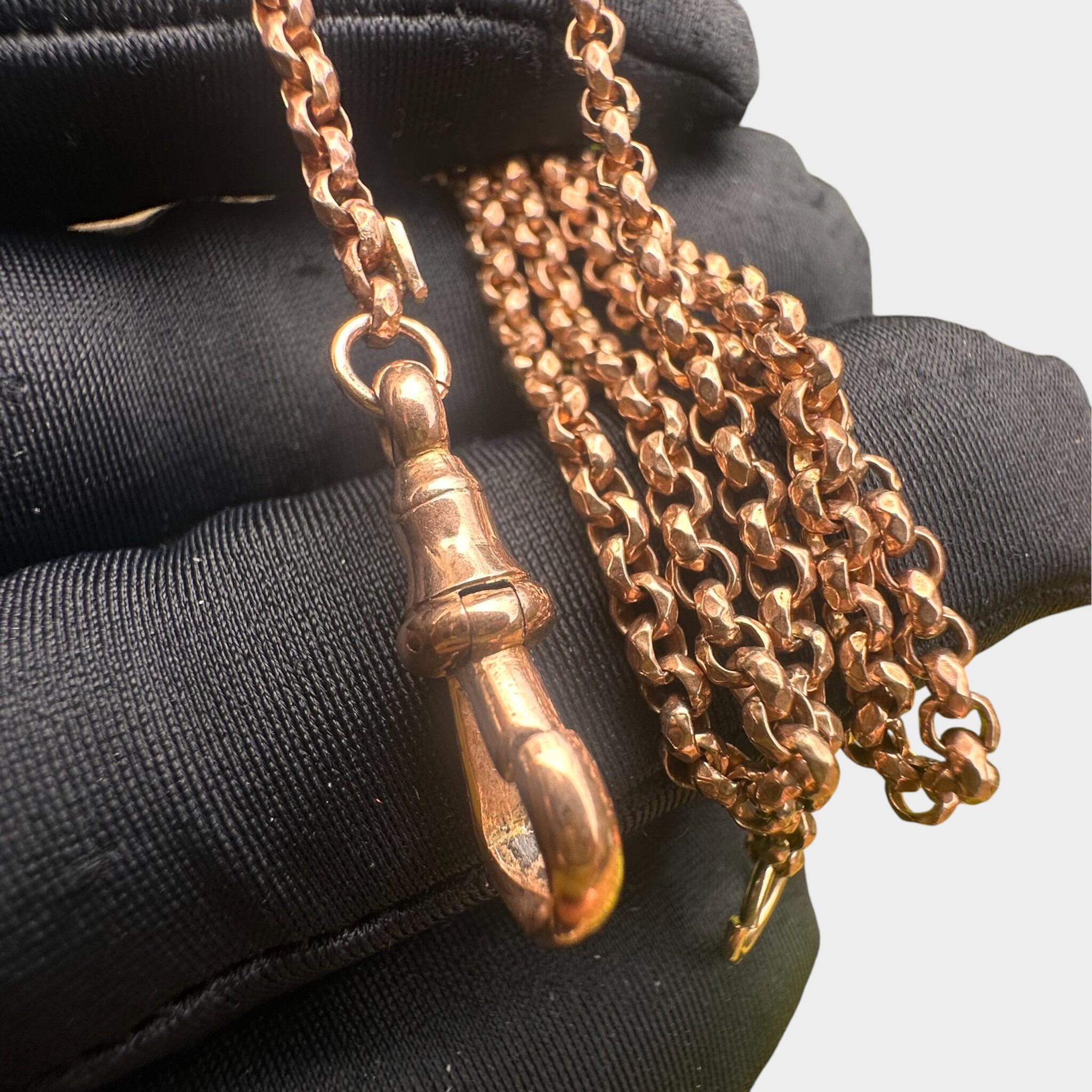 Rose Gold Faceted Belcher Chain with Dog Clip Clasp held on gloved hand, grey background