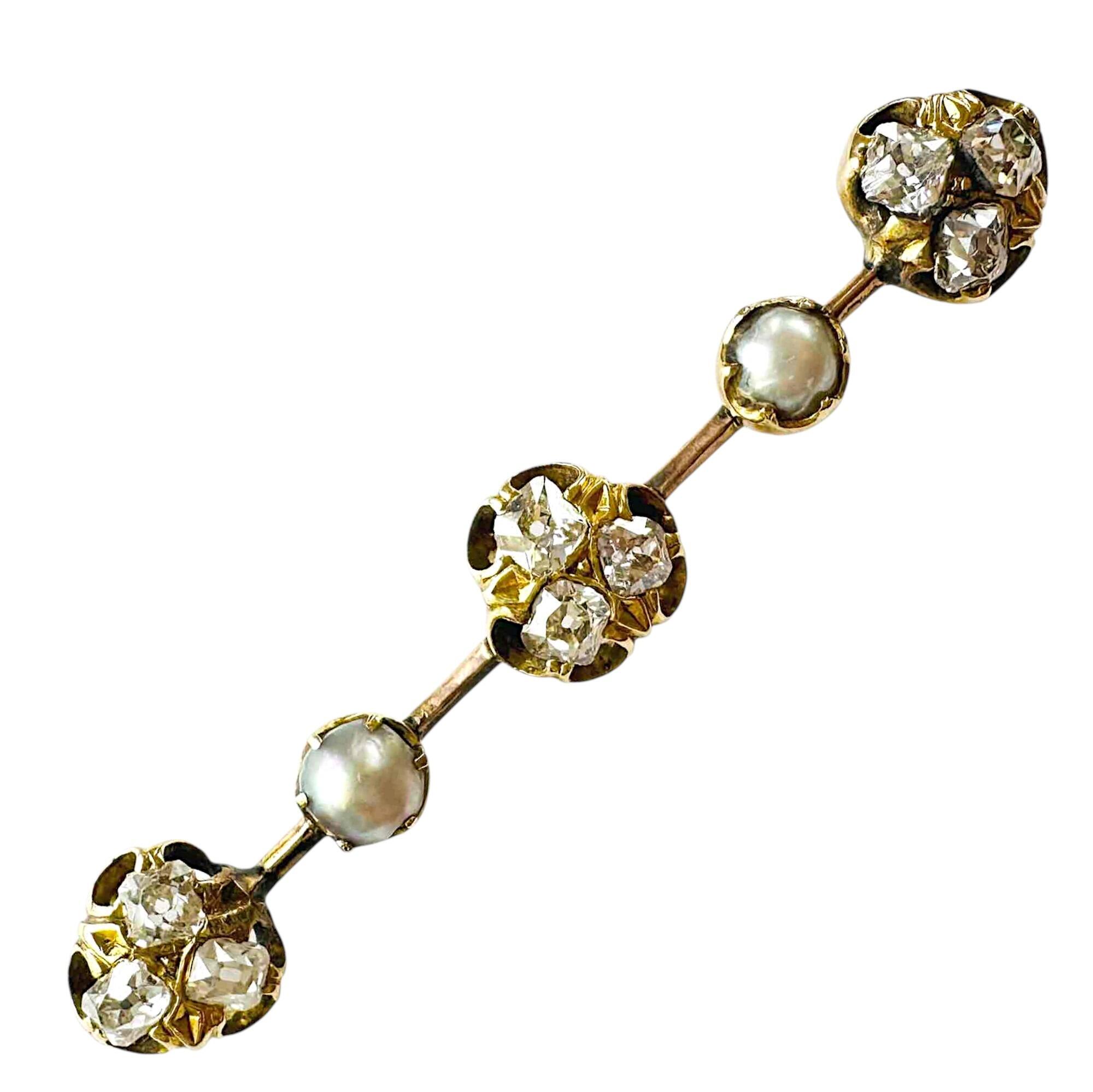 Victorian bar brooch with three, triple diamond clusters interspersed with pearls on white background
