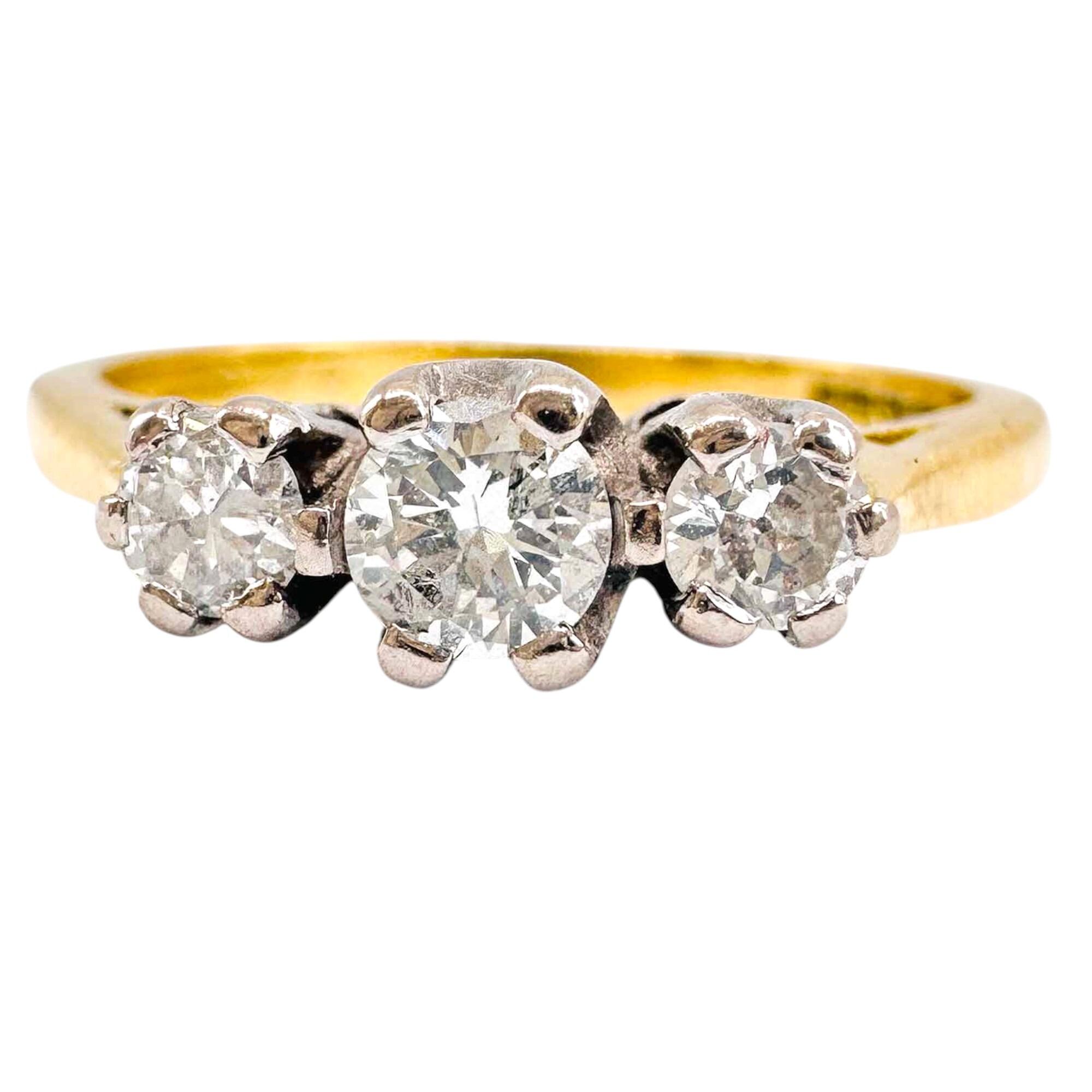 18ct gold trilogy ring with 3.2mm central diamond, two 2.8mm diamonds, SI2 clarity, H color, 0.30ct total weight, yellow gold shank.