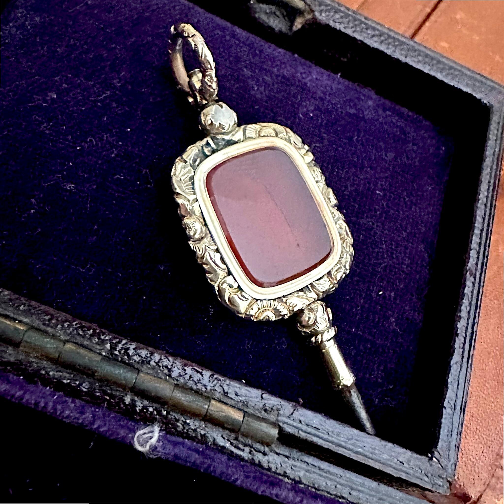 Antique Georgian Carnelian Watch Key Pendant displayed on purple velvet box