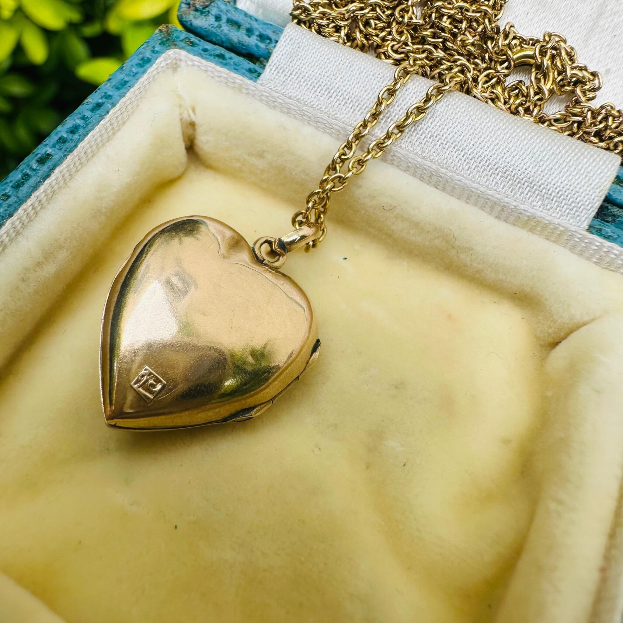 rear view of Vintage Gold Pearl Star Set Puffy Heart Locket displayed on antique box