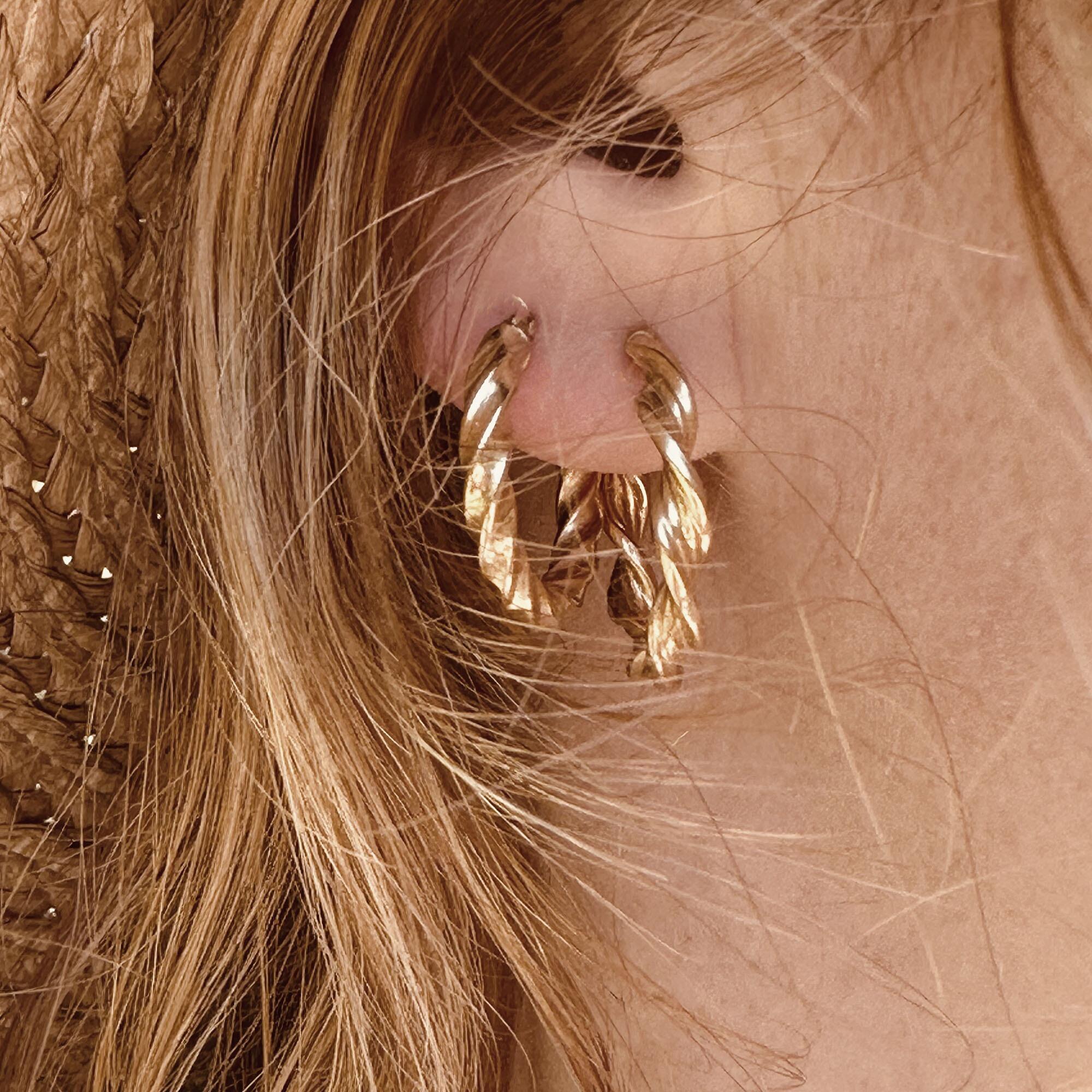 Italian 9k yellow gold twist rope hoop earrings worn by model in sunhat.