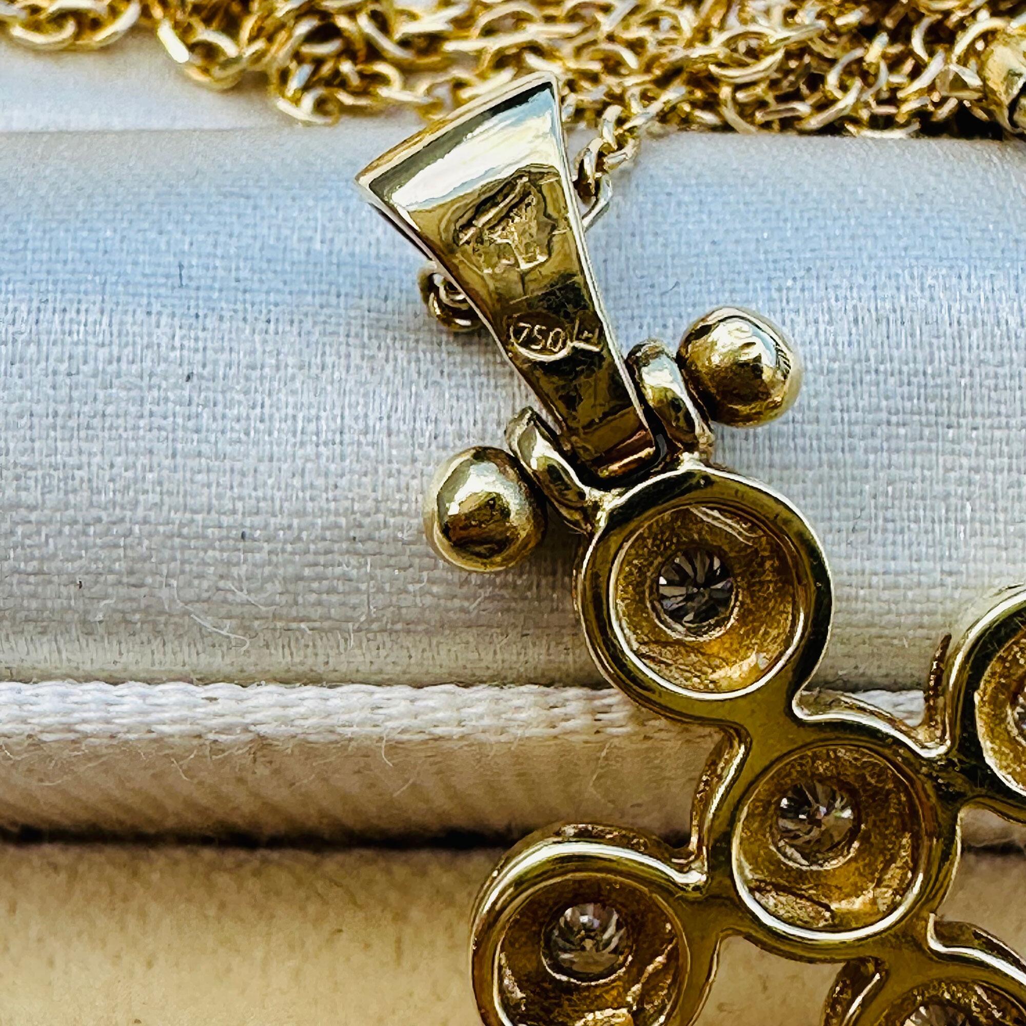 close up of hallmarks of 18ct yellow gold and diamond cross pendant