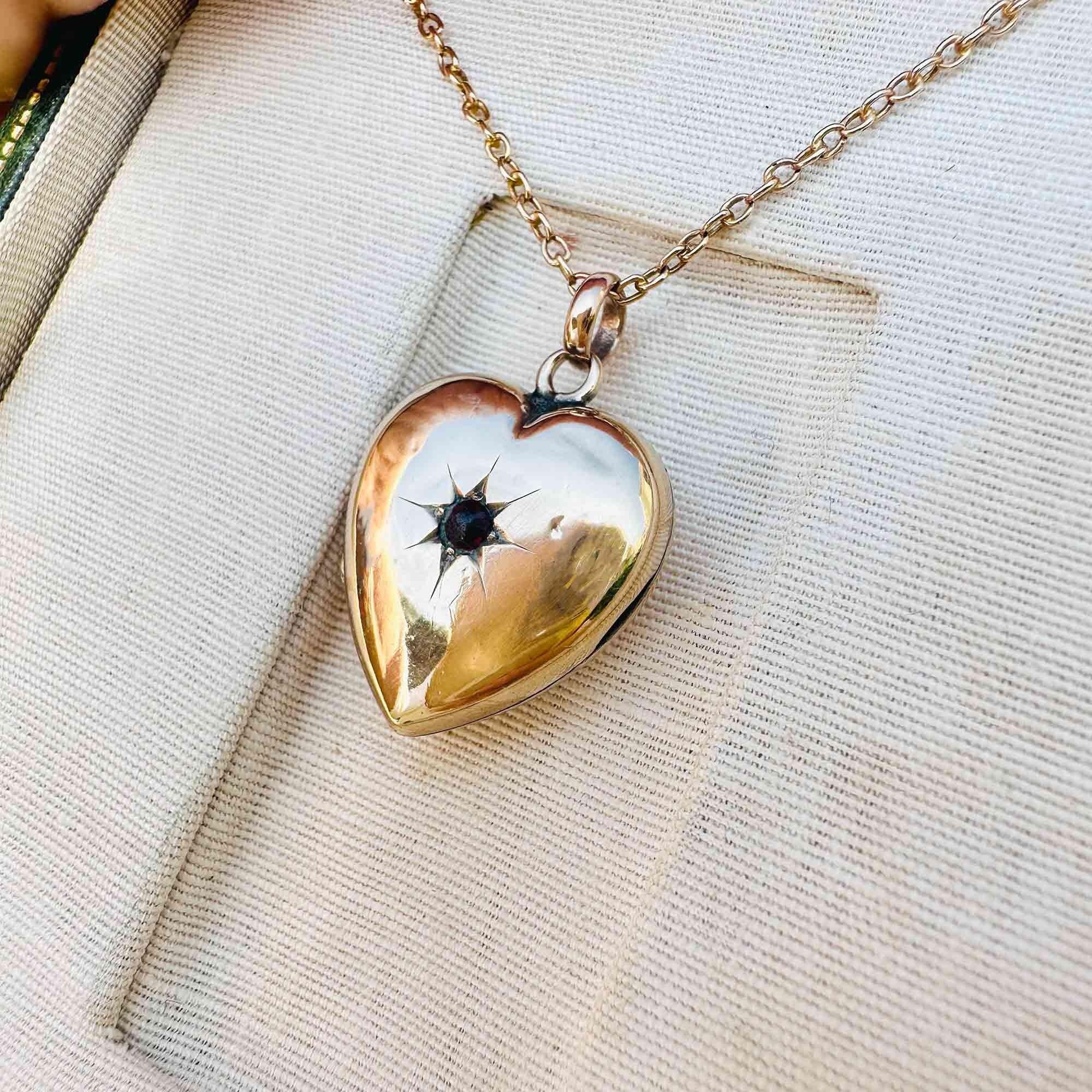 Victorian Gold Heart Locket Pendant with Garnet Star-Set Detail, displayed in antique box.