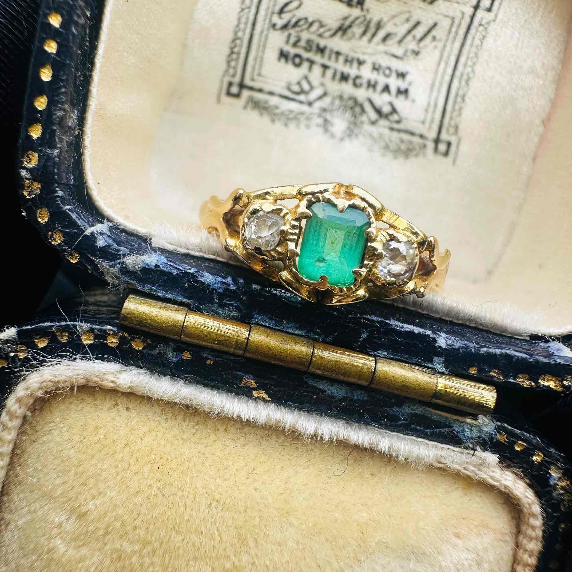 Emerald & Diamond Three Stone Victorian Ring displayed on antique box