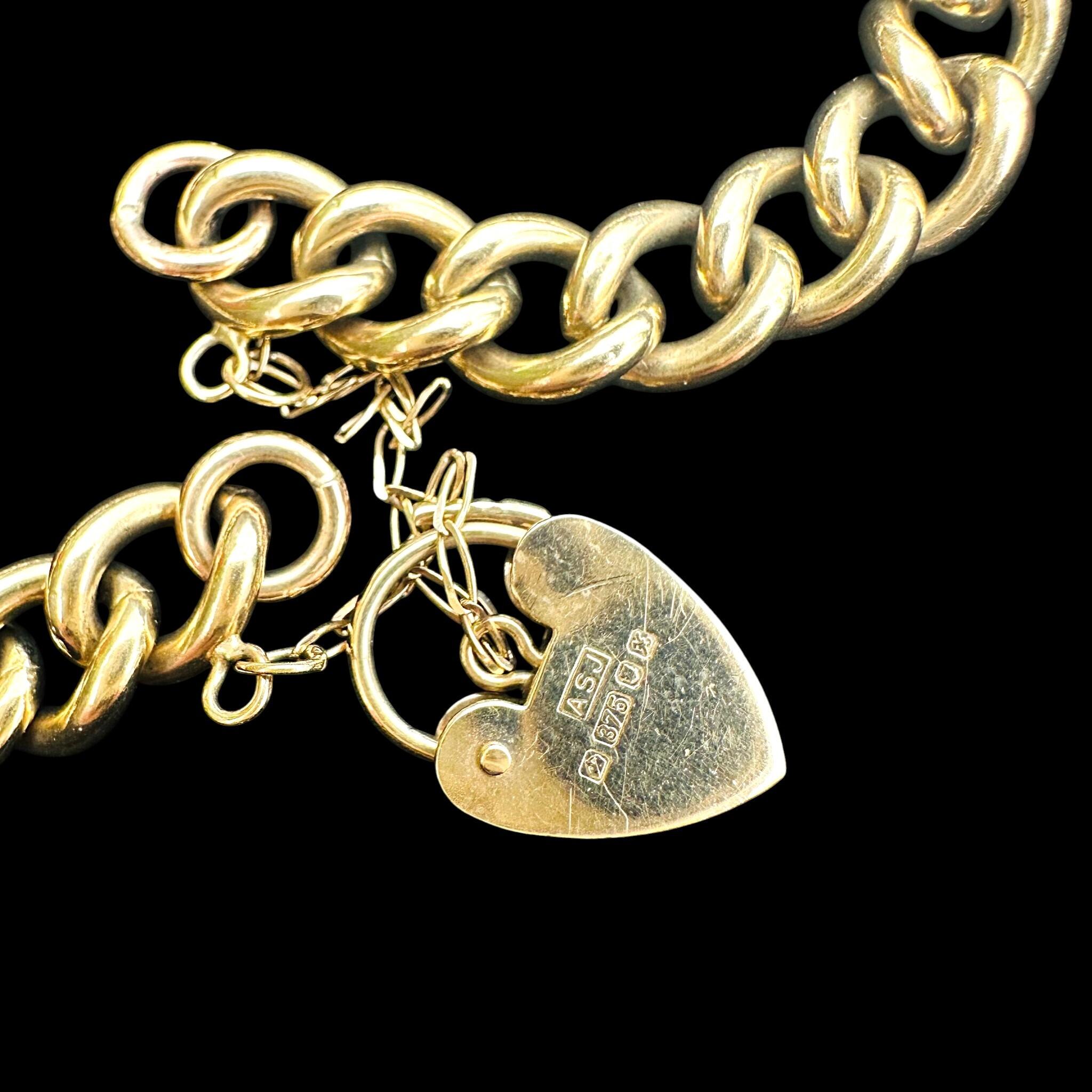 close up of Heavy, Chunky Gold Curb Bracelet & Heart Padlock displayed on antique box