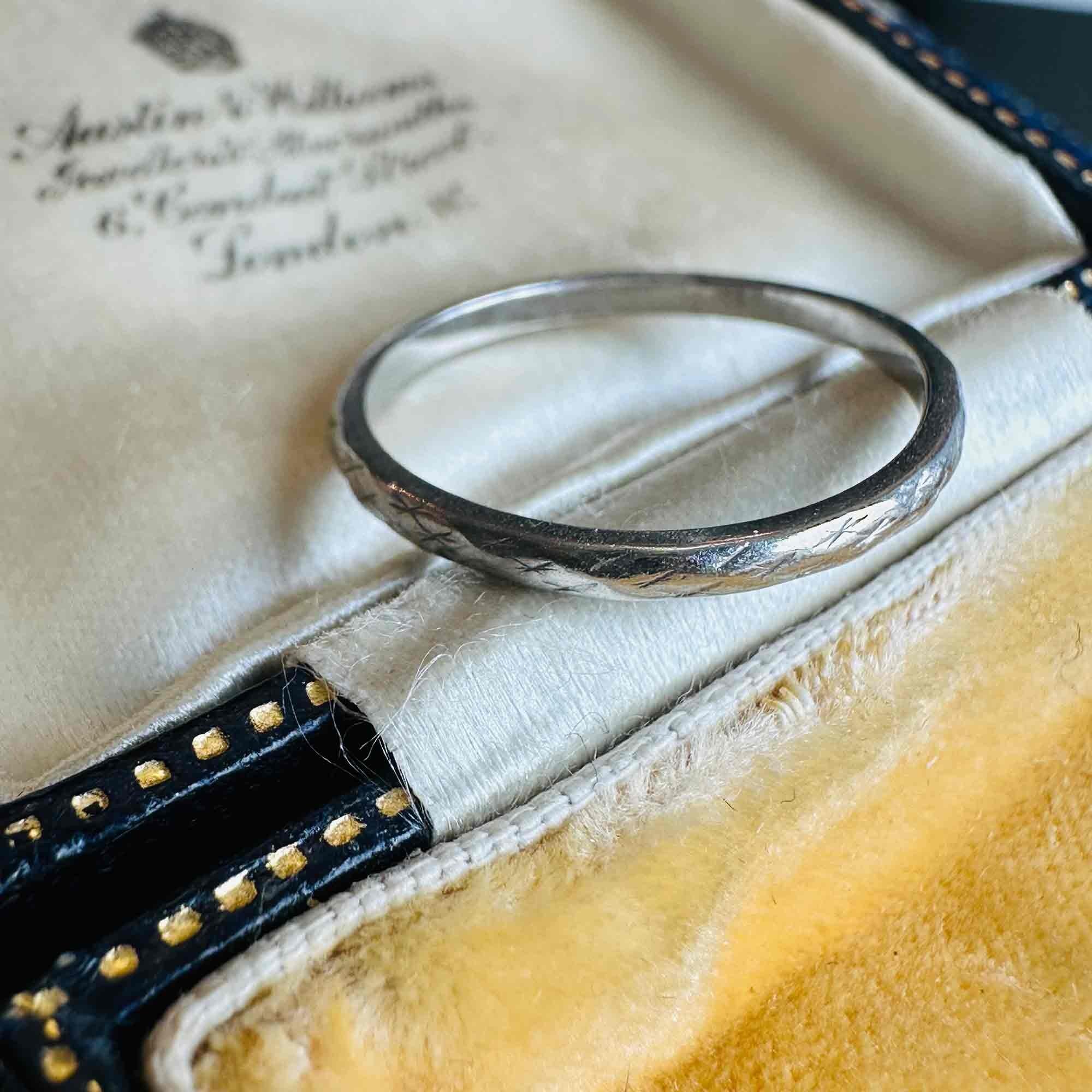 Art Deco Hand Engraved Platinum Wedding Band displayed on antique box