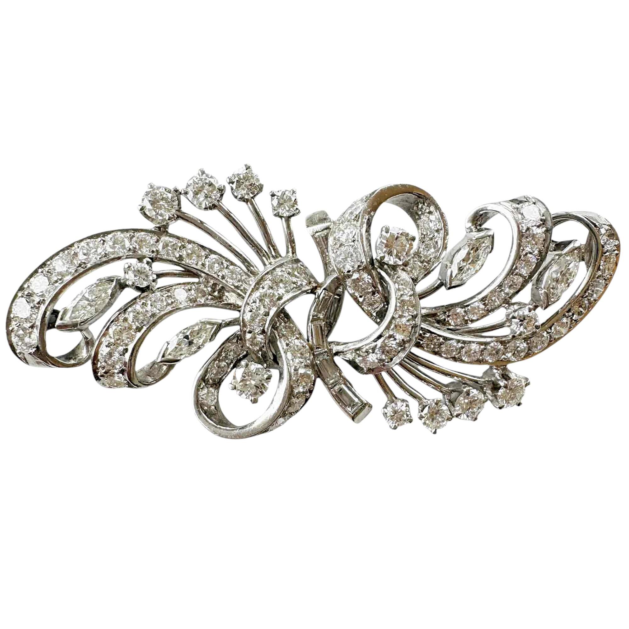 platinum art deco brooch in a cascading scrollwork design set with diamonds on white background