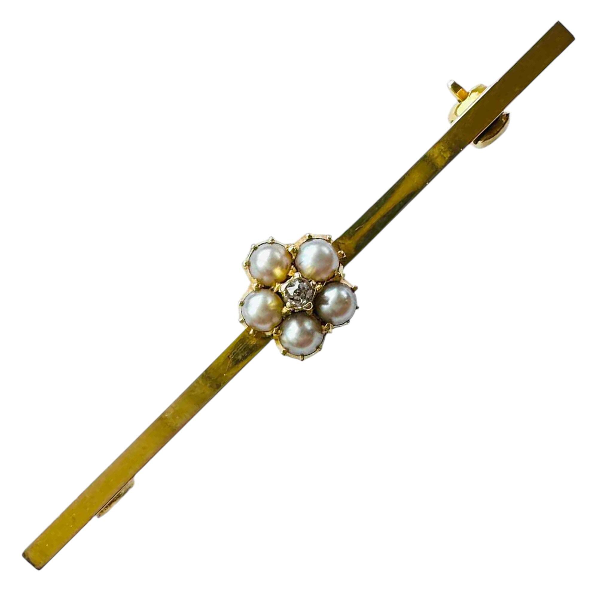 Antique Edwardian brooch with pearl and diamond cluster on gold bar, 9ct hallmark on white background