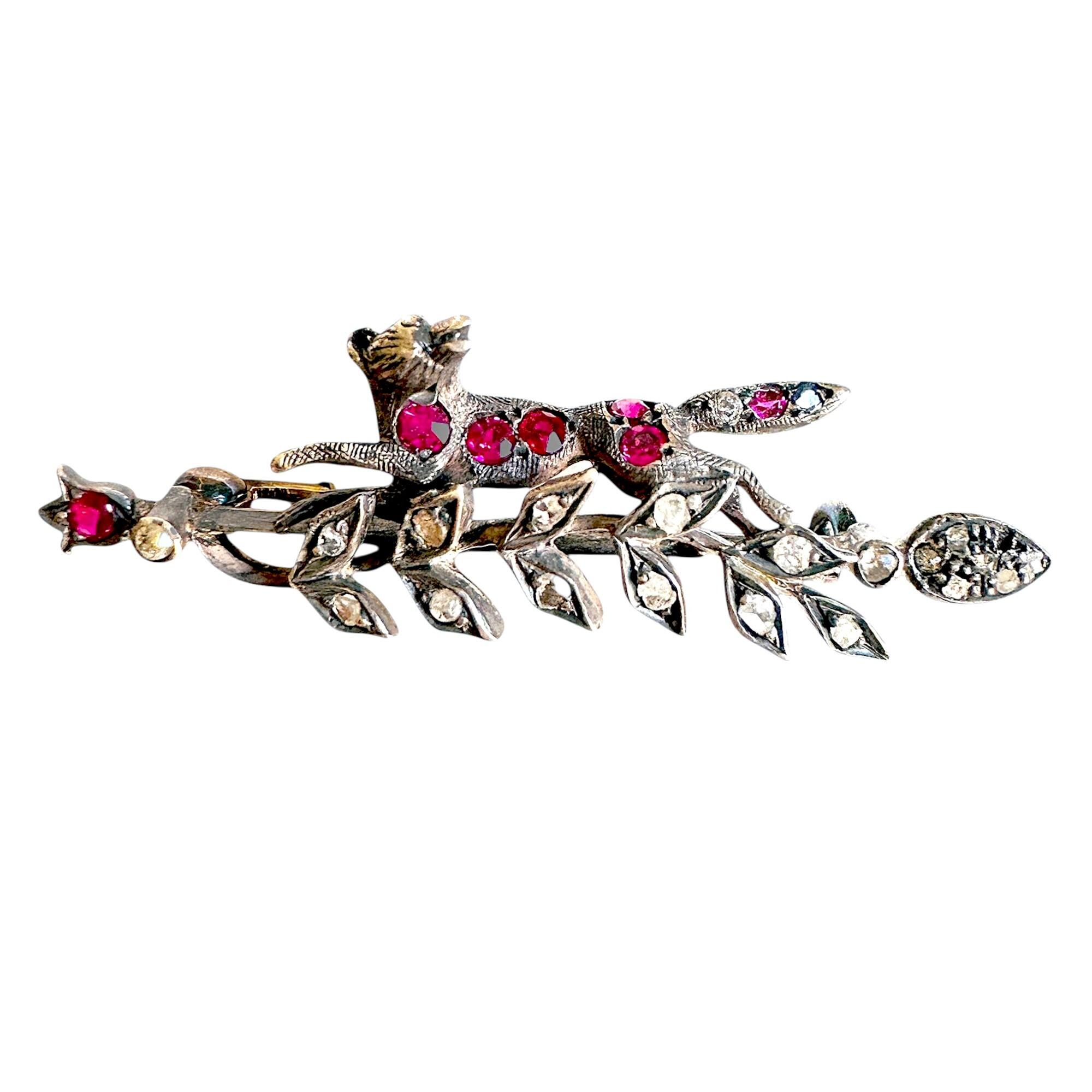 antique brooch featuring gemstone set fox running along a foliate mounted bar
