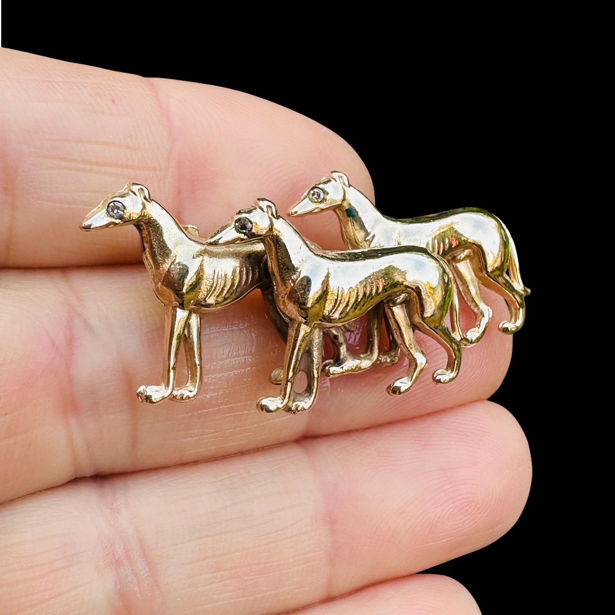 Rare, Antique 15k Gold Triple Greyhound Brooch with Diamond Eyes, held in models hand.