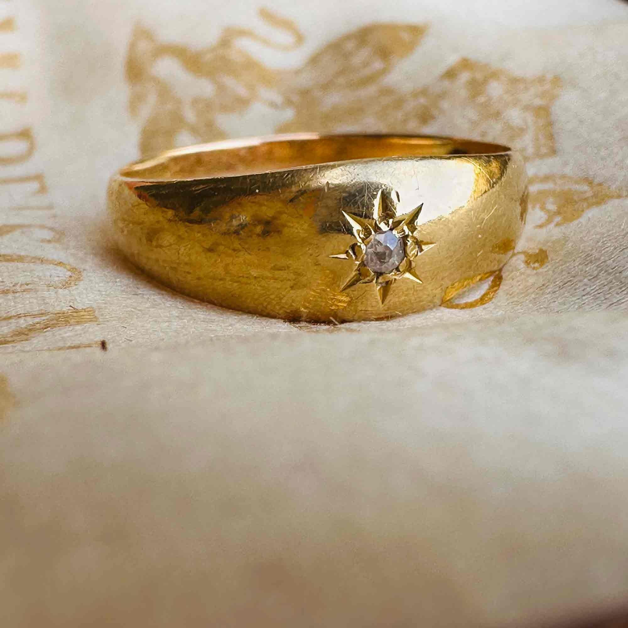 close up 18ct Gold & Diamond Star Set Gypsy Ring, displayed on antique box