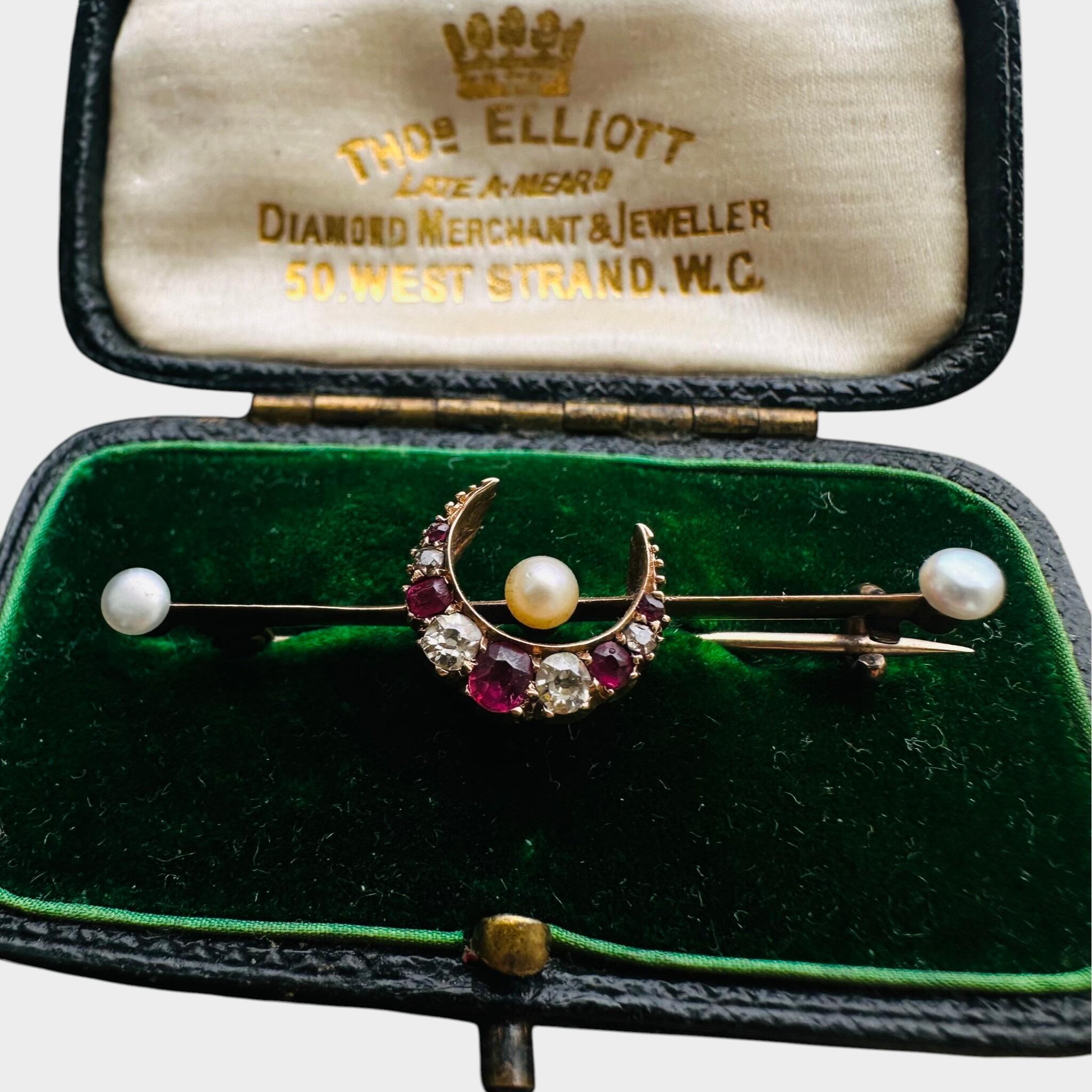 15ct Gold Diamond, Ruby & Pearl Crescent Moon Brooch displayed on green velvet antique box