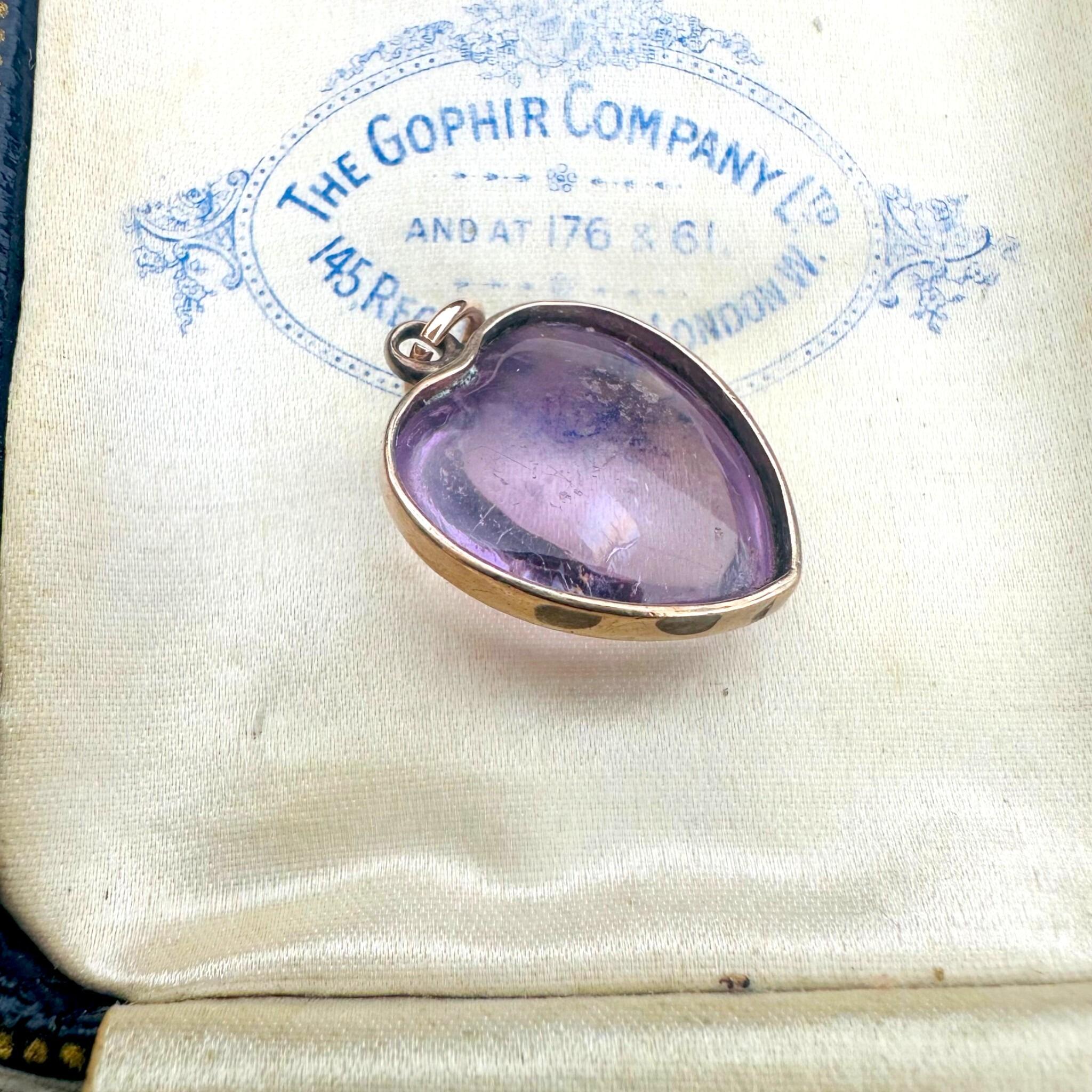 side profile of Rose de France Amethyst Heart Pendant & Gold rolo link chain displayed on antique box