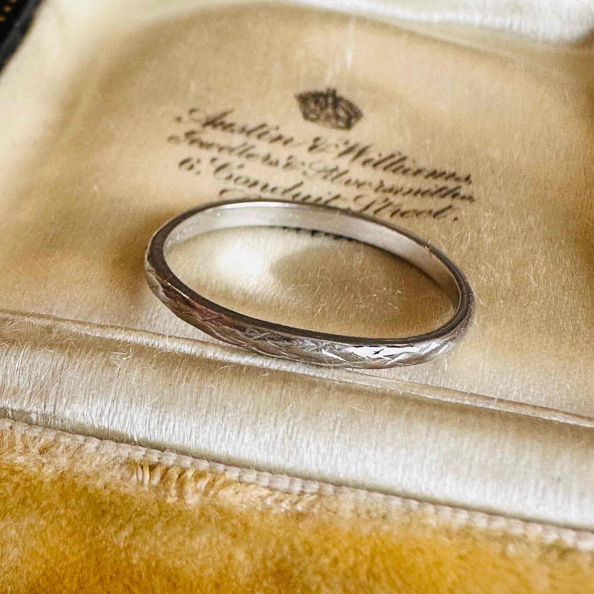Art Deco Hand Engraved Platinum Wedding Band displayed on antique box