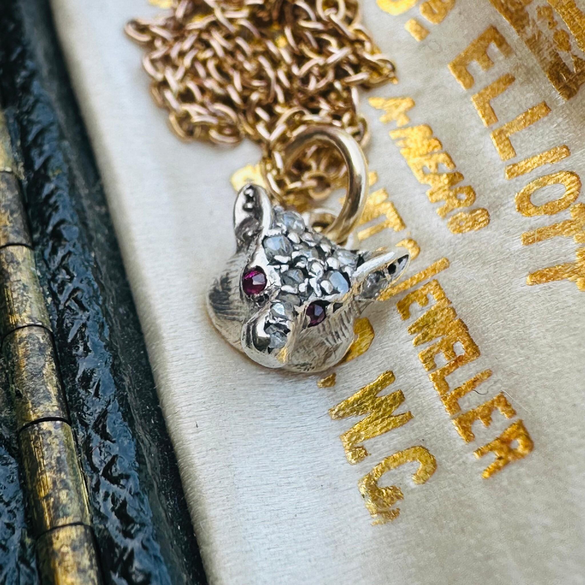 Victorian Diamond & Ruby Eyes Fox Pendant displayed laying on antique box