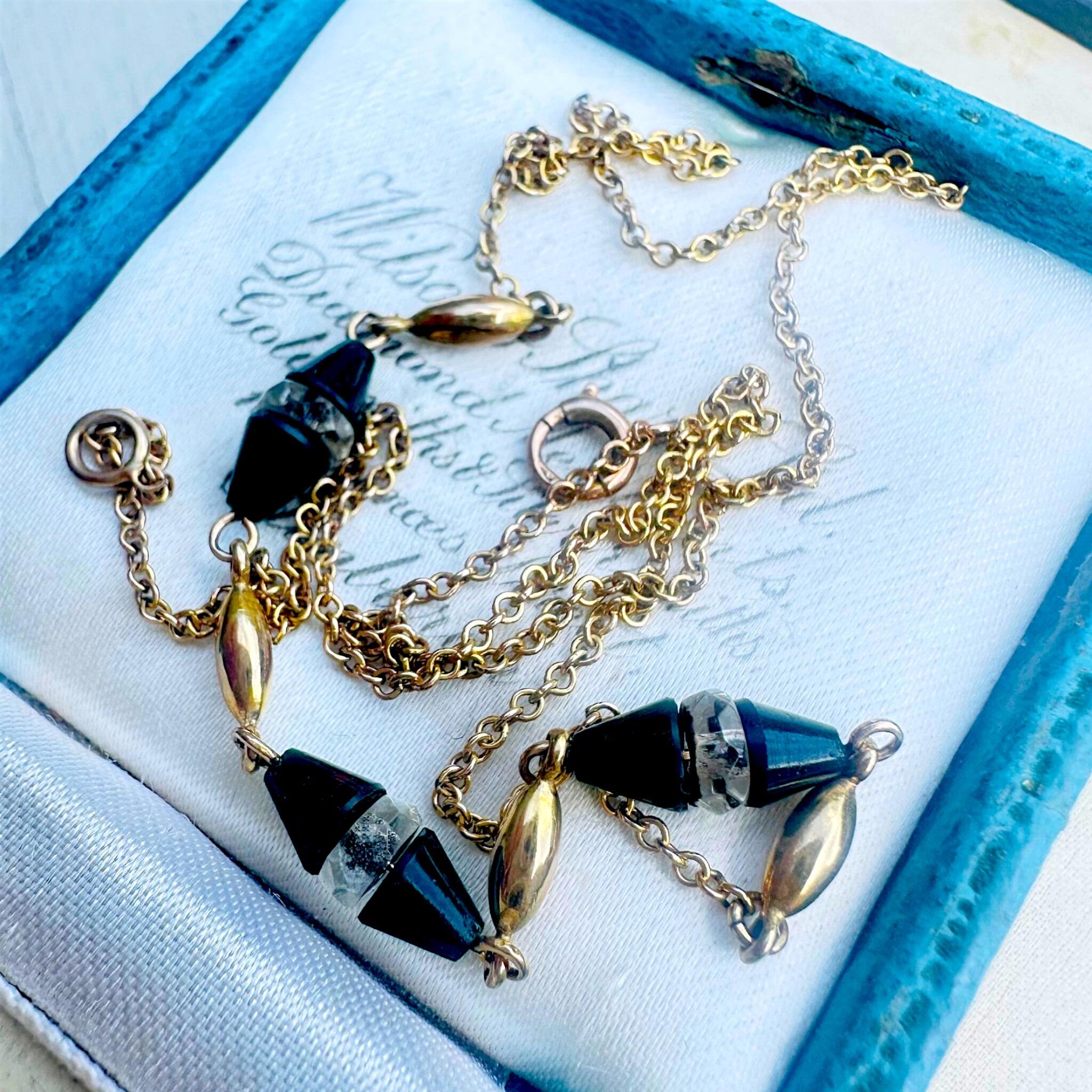 Antique Art Deco 9k Gold Bloodstone & Rock Crystal Bead Chain displayed on antique box