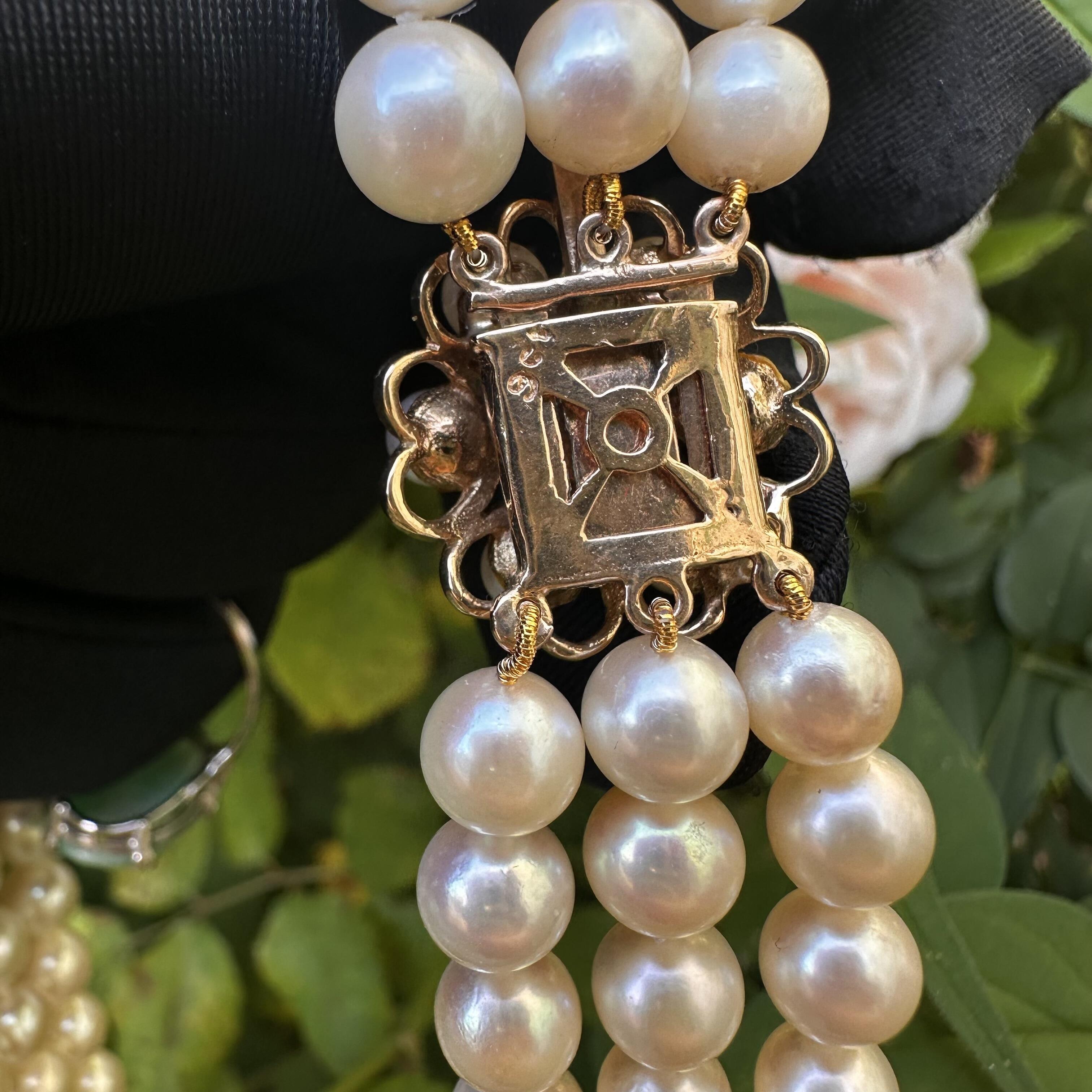 rear view of Vintage Cultured Saltwater Pearl 3 Row Necklace with Gold Pearl Cluster Heart Clasp held in garden