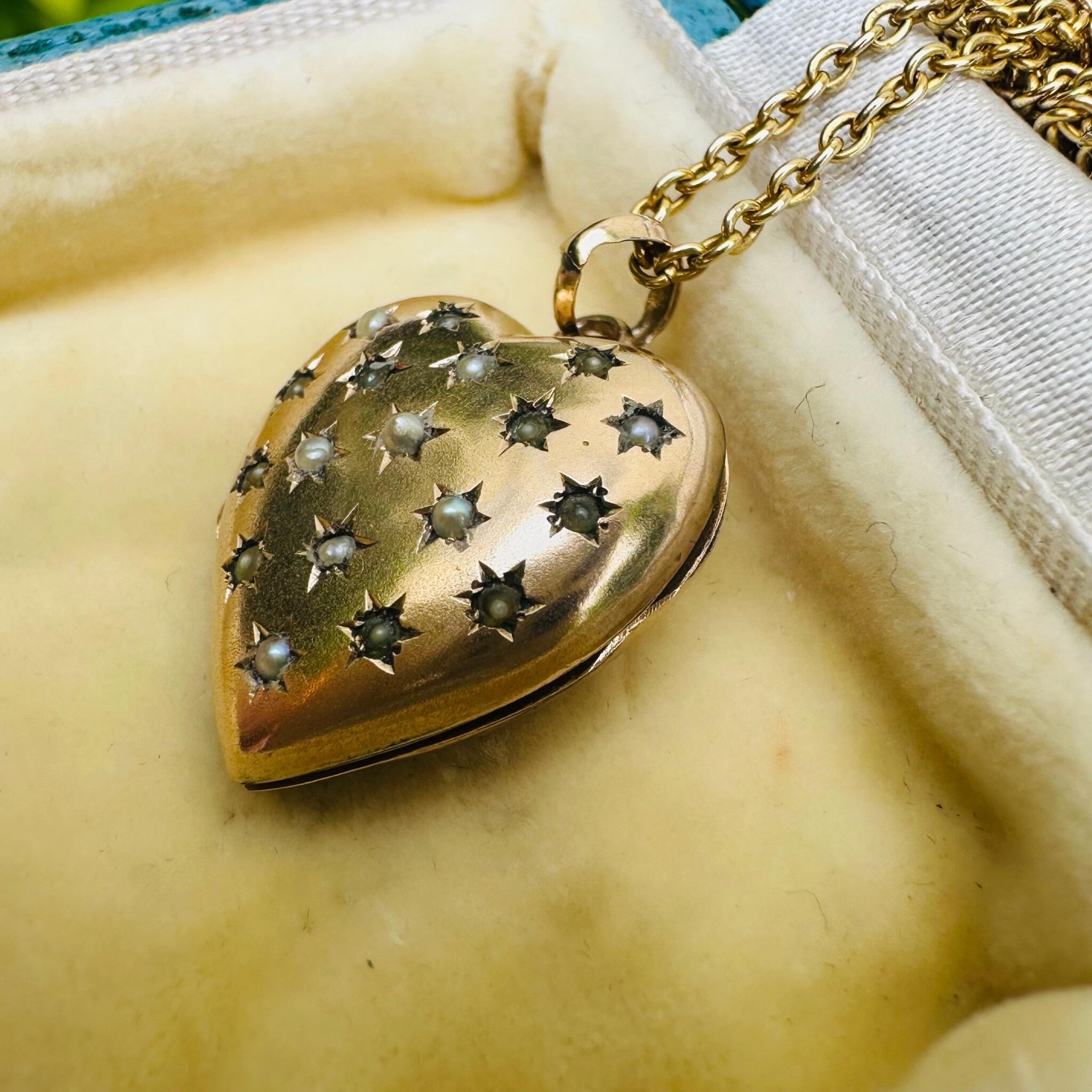 side profile of Vintage Gold Pearl Star Set Puffy Heart Locket displayed on antique box