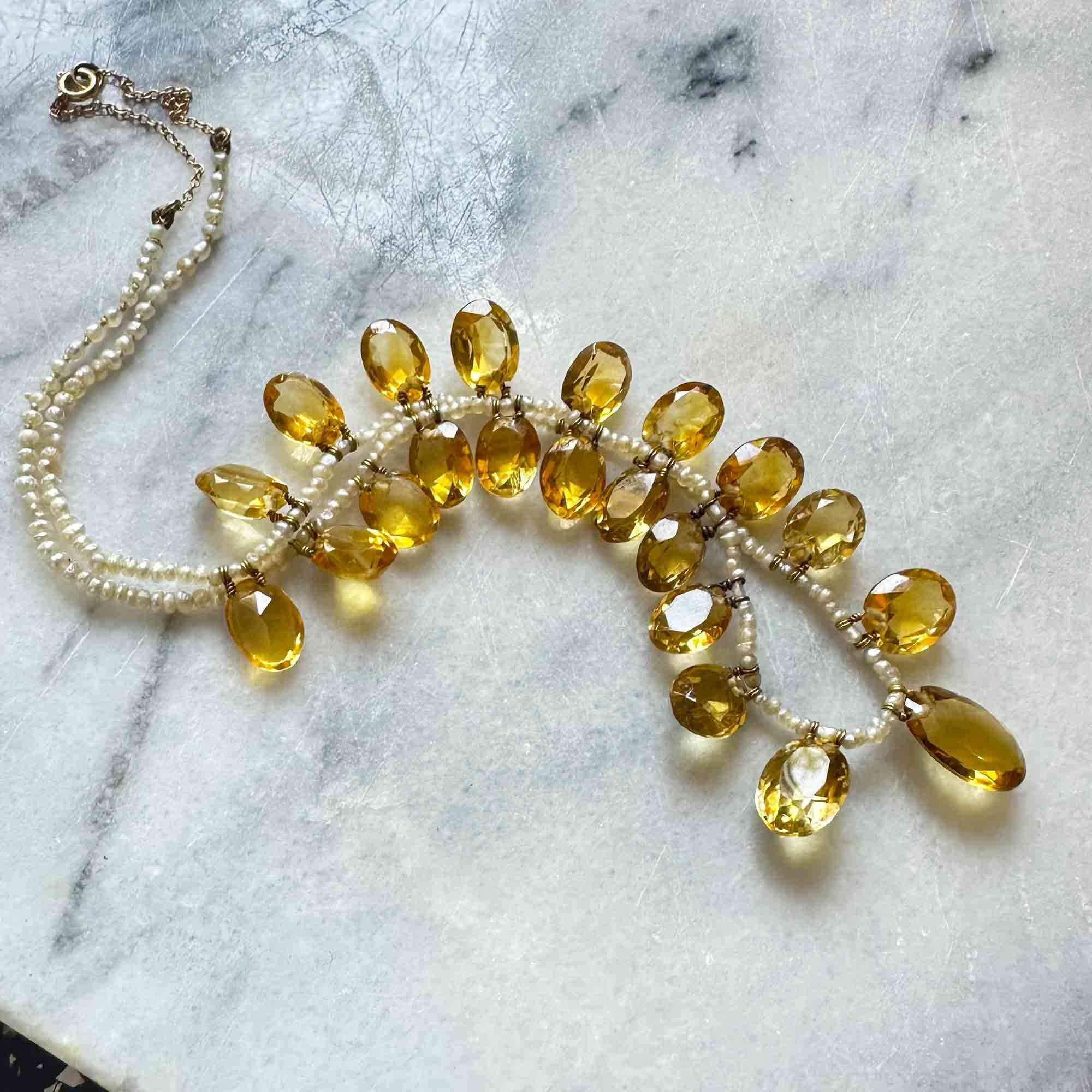 Necklace laid flat showing graduated citrine sizes and pearl spacing