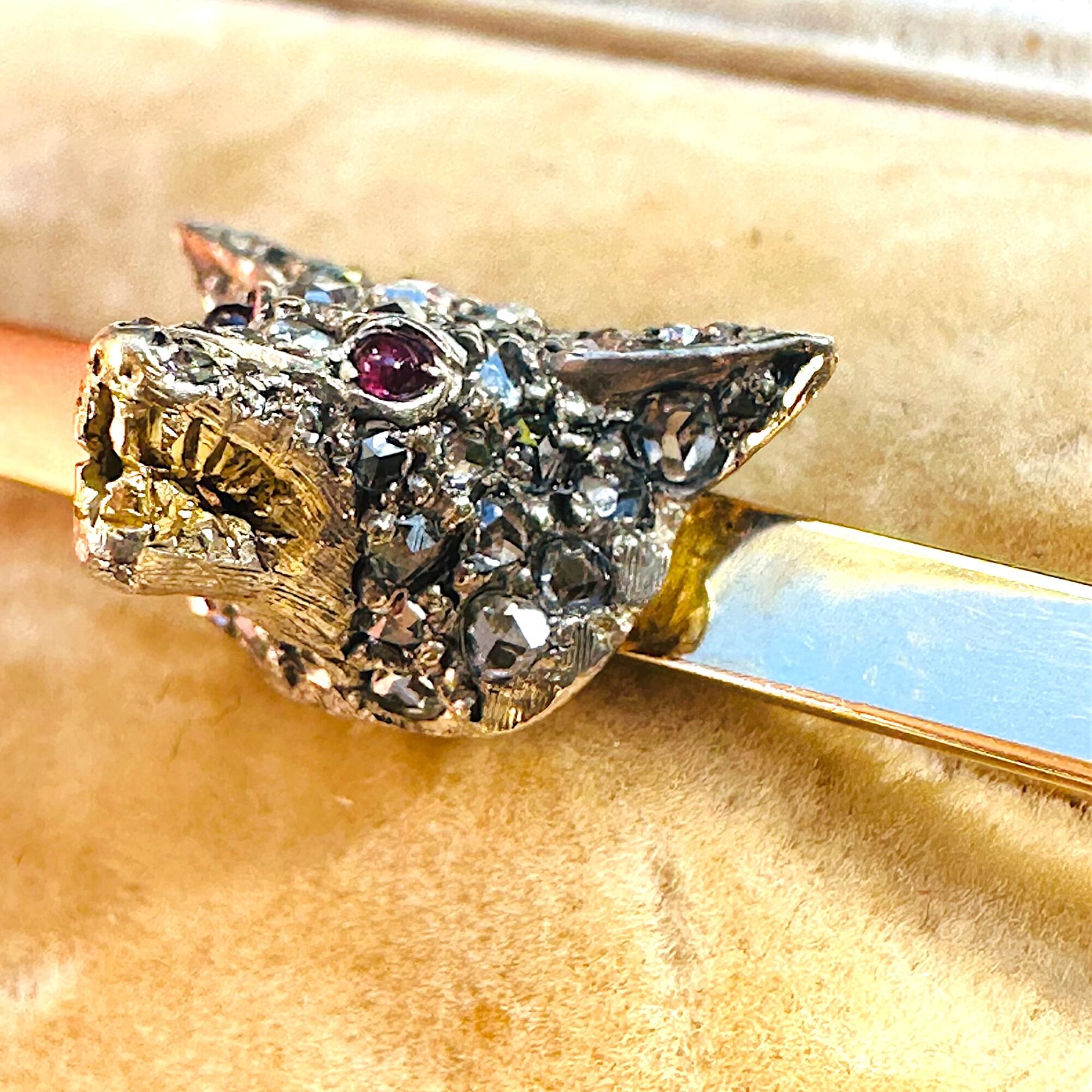 close up of Antique diamond fox head brooch with rose cut diamonds, ruby eyes, and gold teeth detail