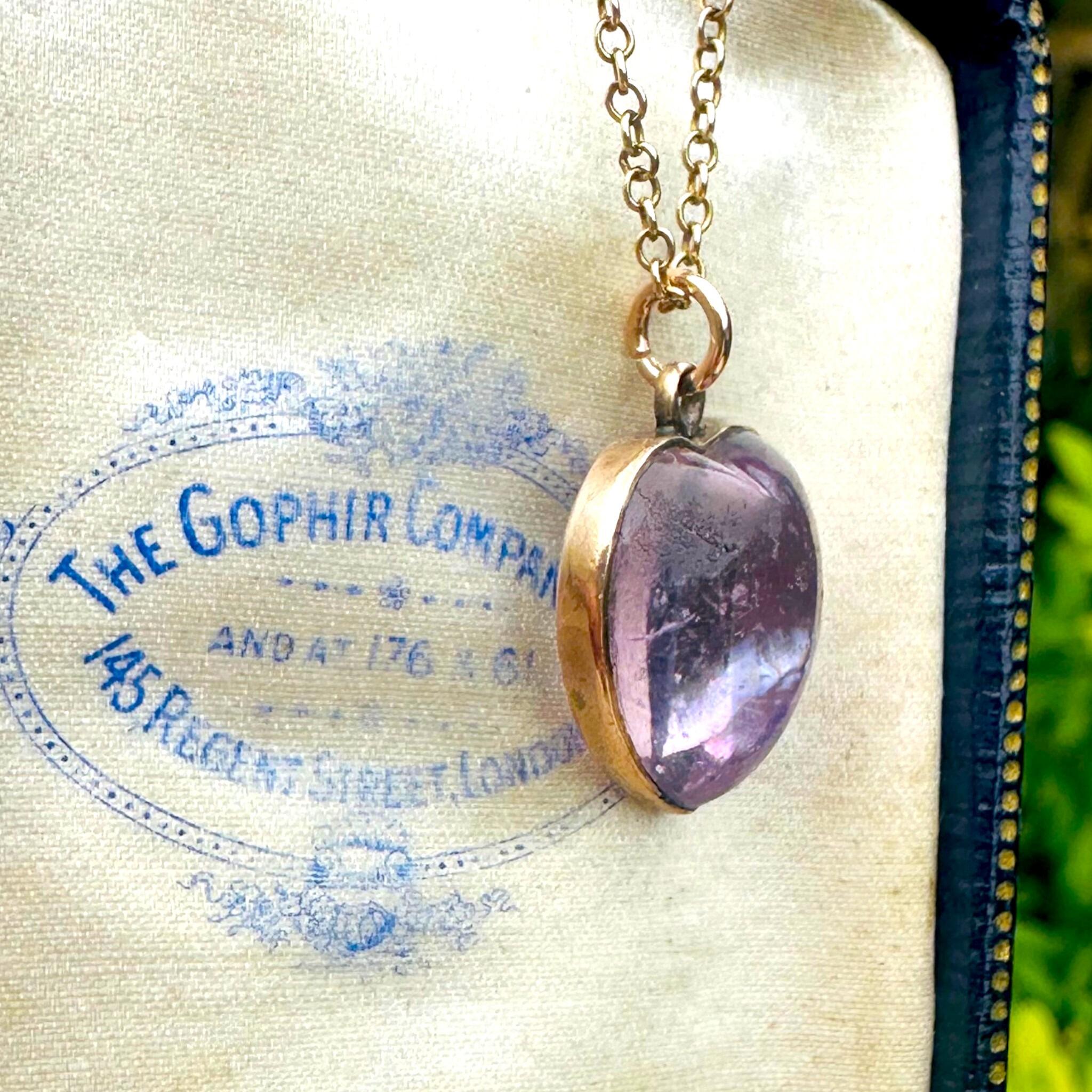 side profile of Rose de France Amethyst Heart Pendant & Gold rolo link chain displayed on antique box