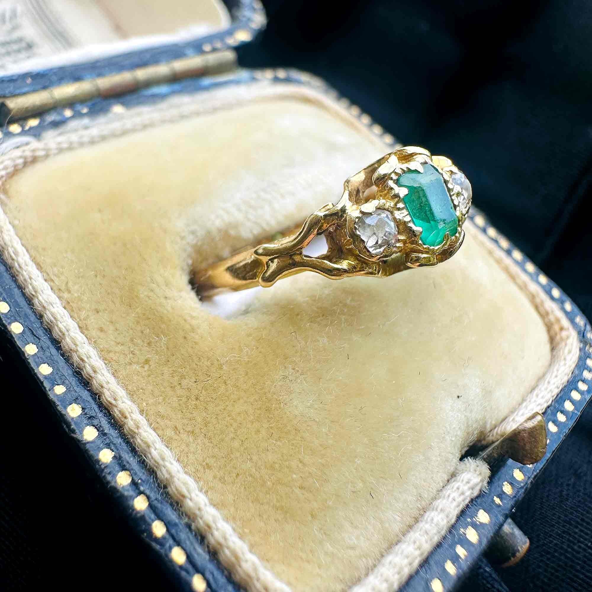 side view of Emerald & Diamond Three Stone Victorian Ring displayed on antique box