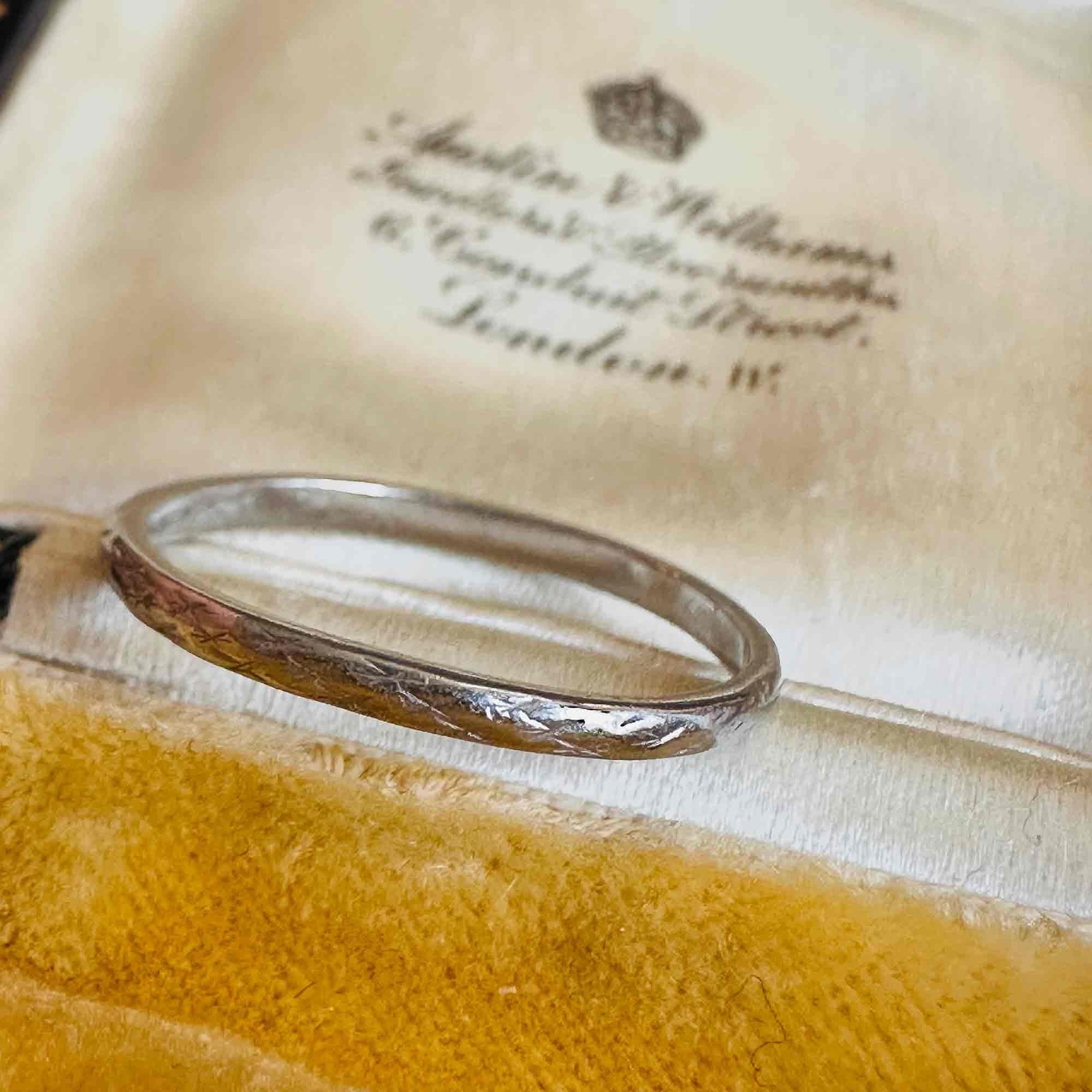 Art Deco Hand Engraved Platinum Wedding Band displayed on antique box